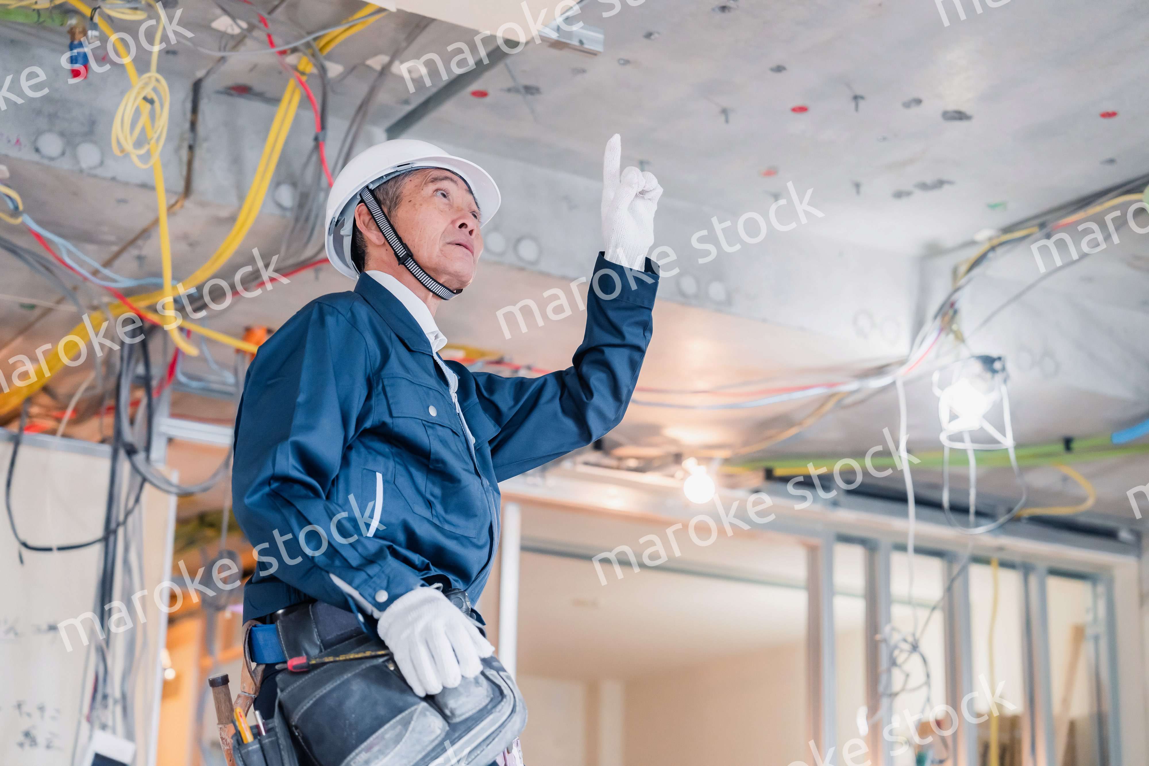 工事中の現場で指差し確認をする職人