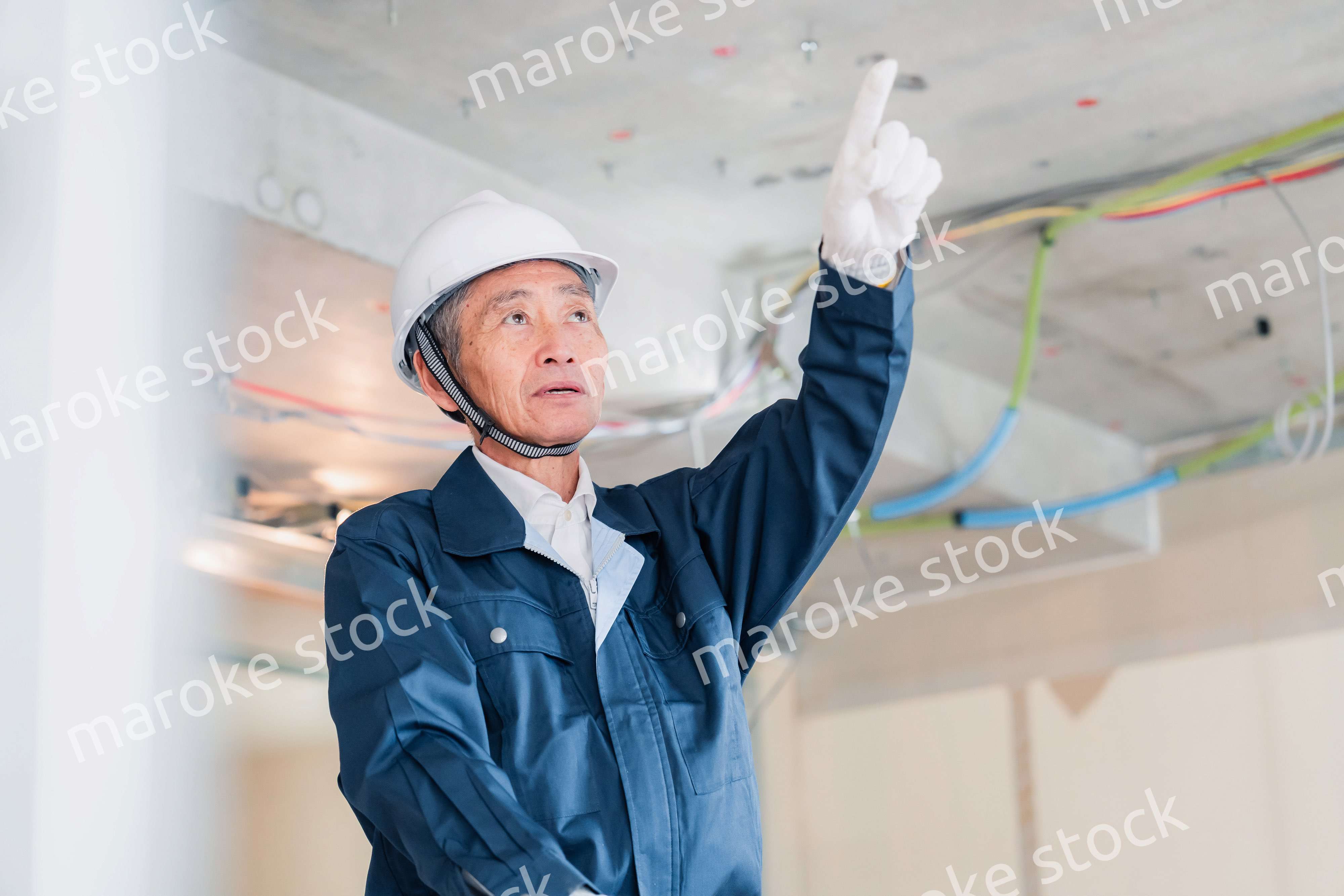 工事中の現場で指差し確認をする職人