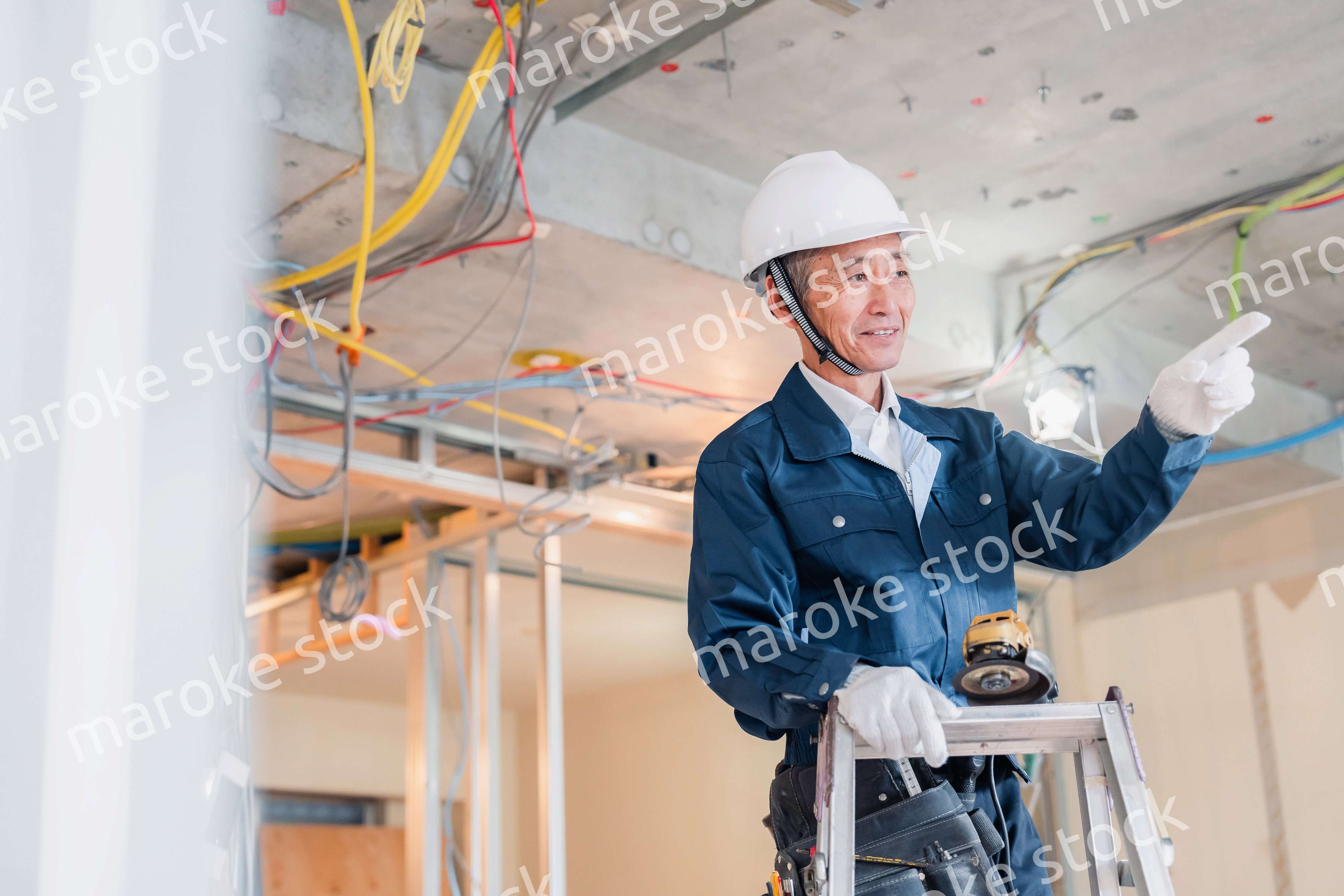 工事中の現場で指差し確認をする職人