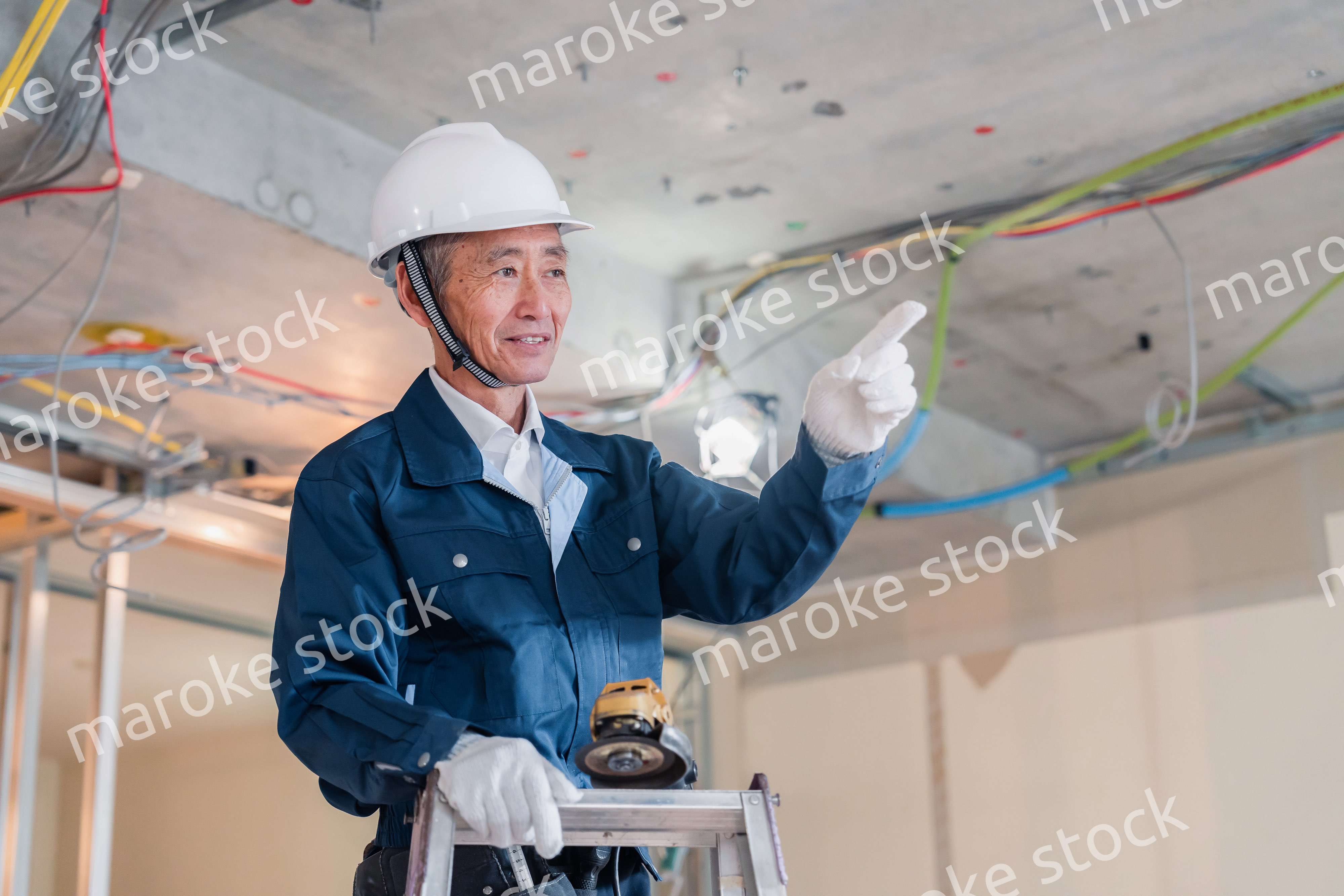 工事中の現場で指差し確認をする職人