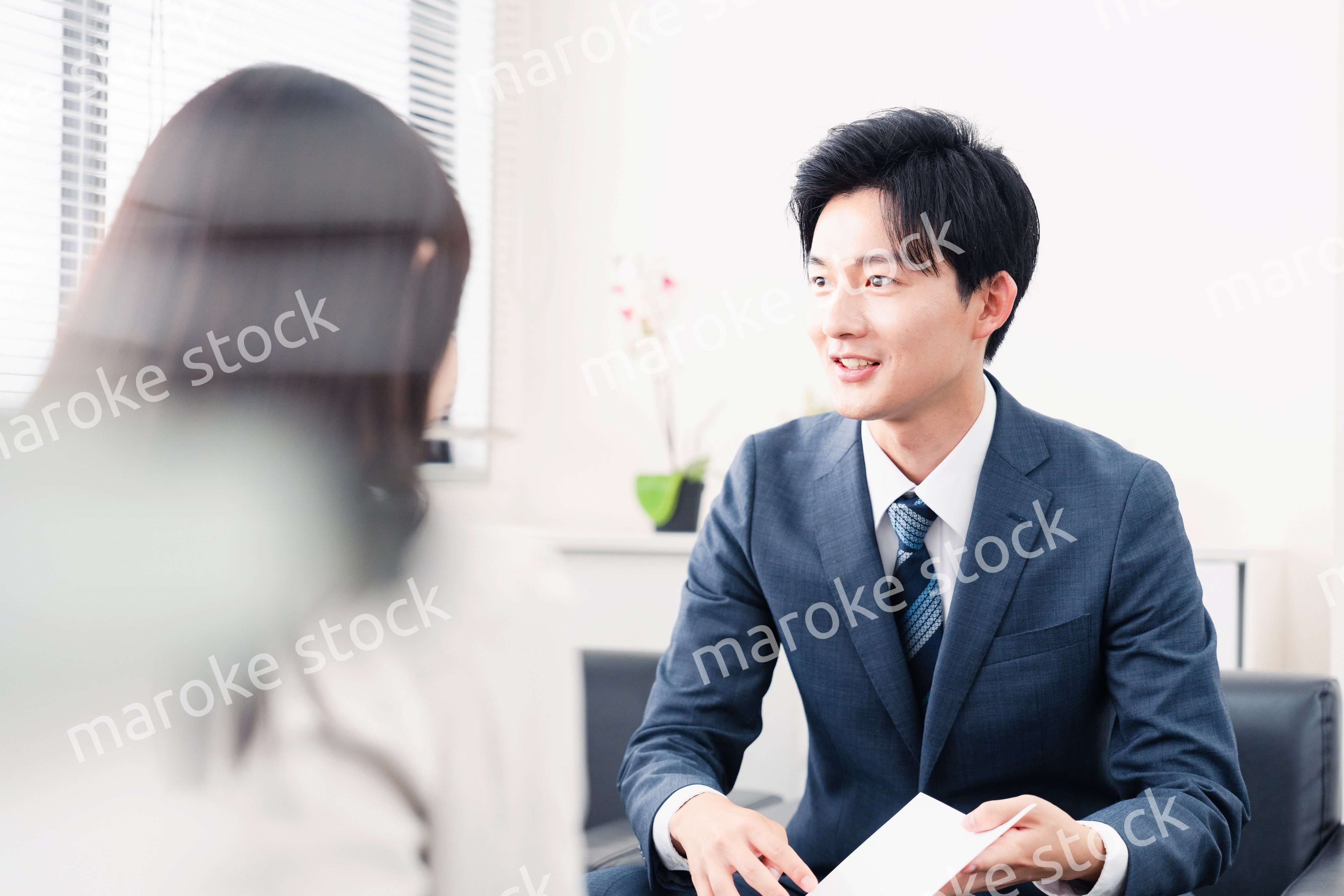 書類を提示する営業マン