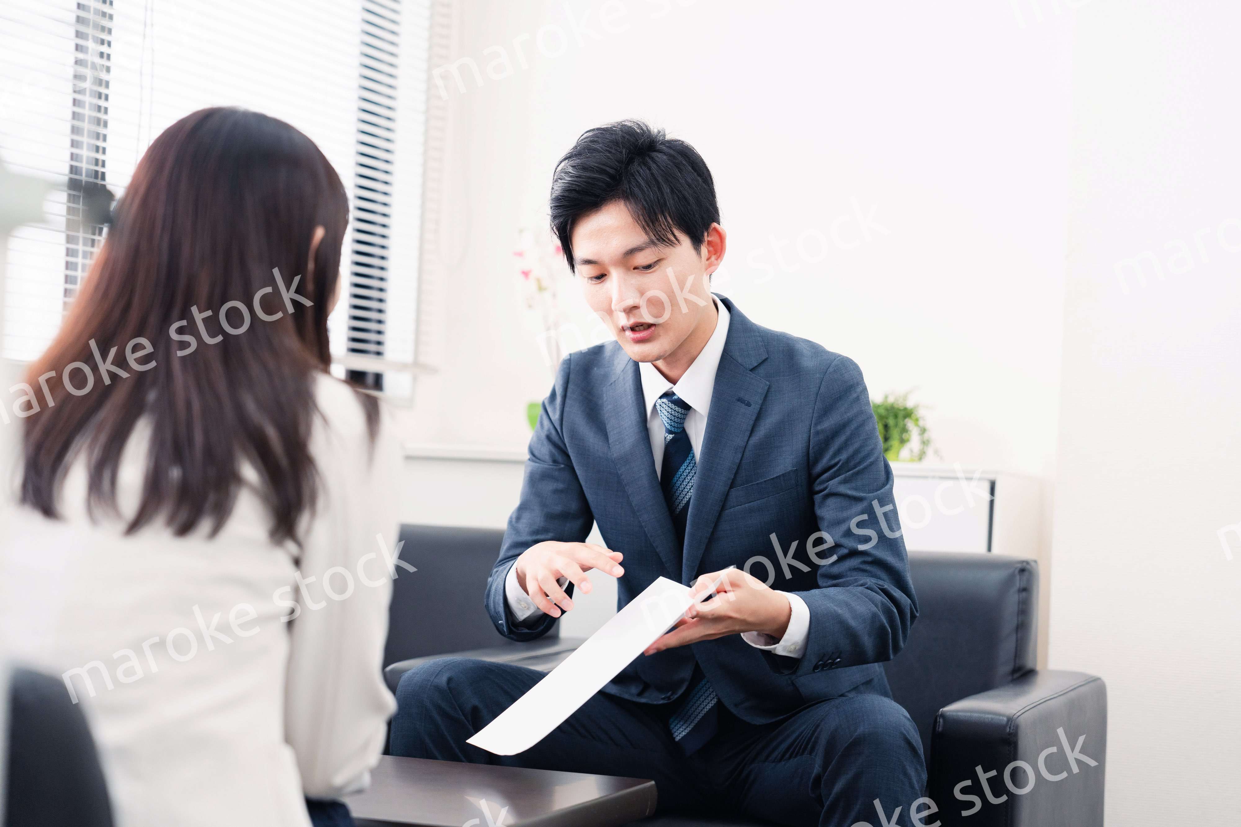 書類を提示する営業マン