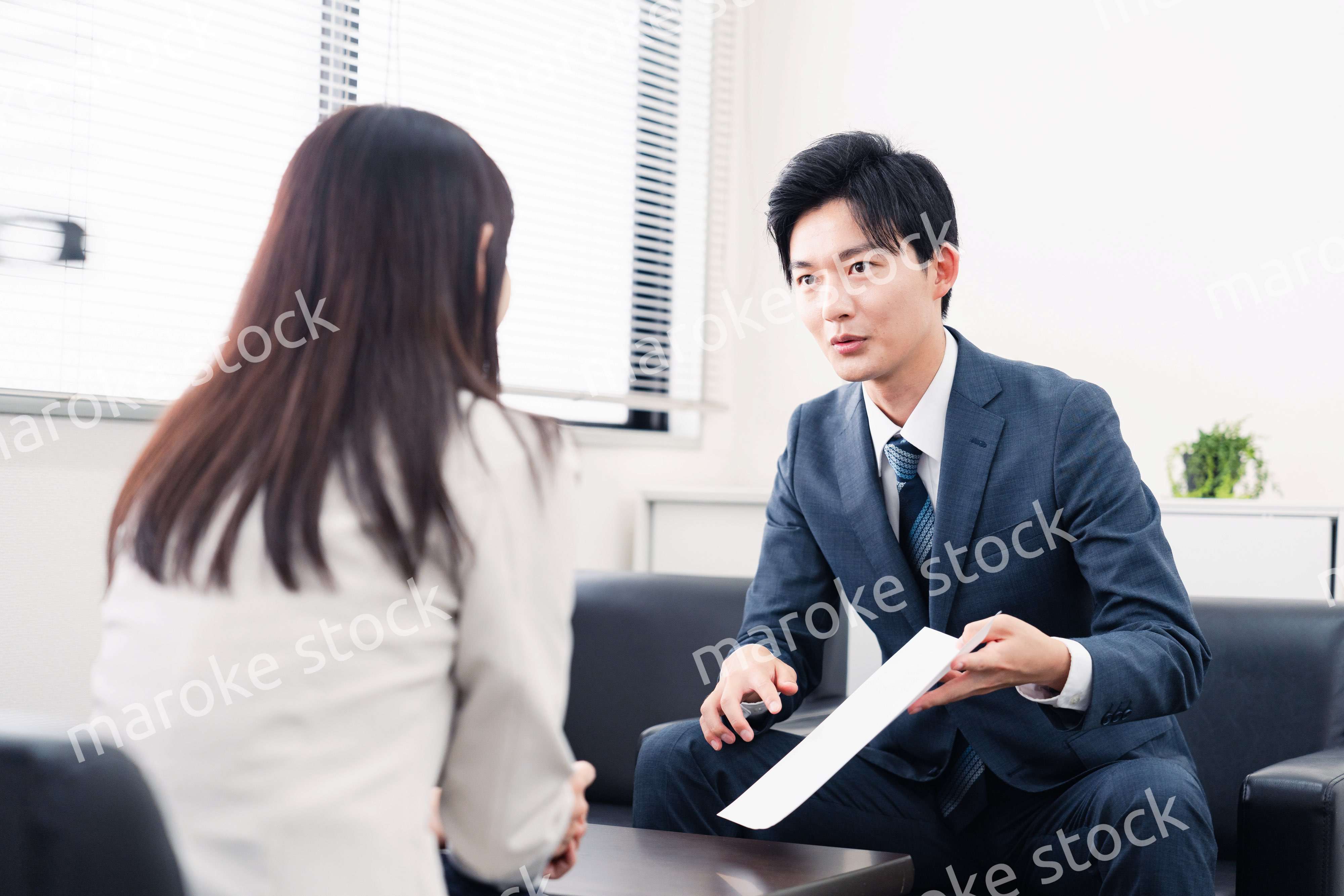 書類を提示する営業マン