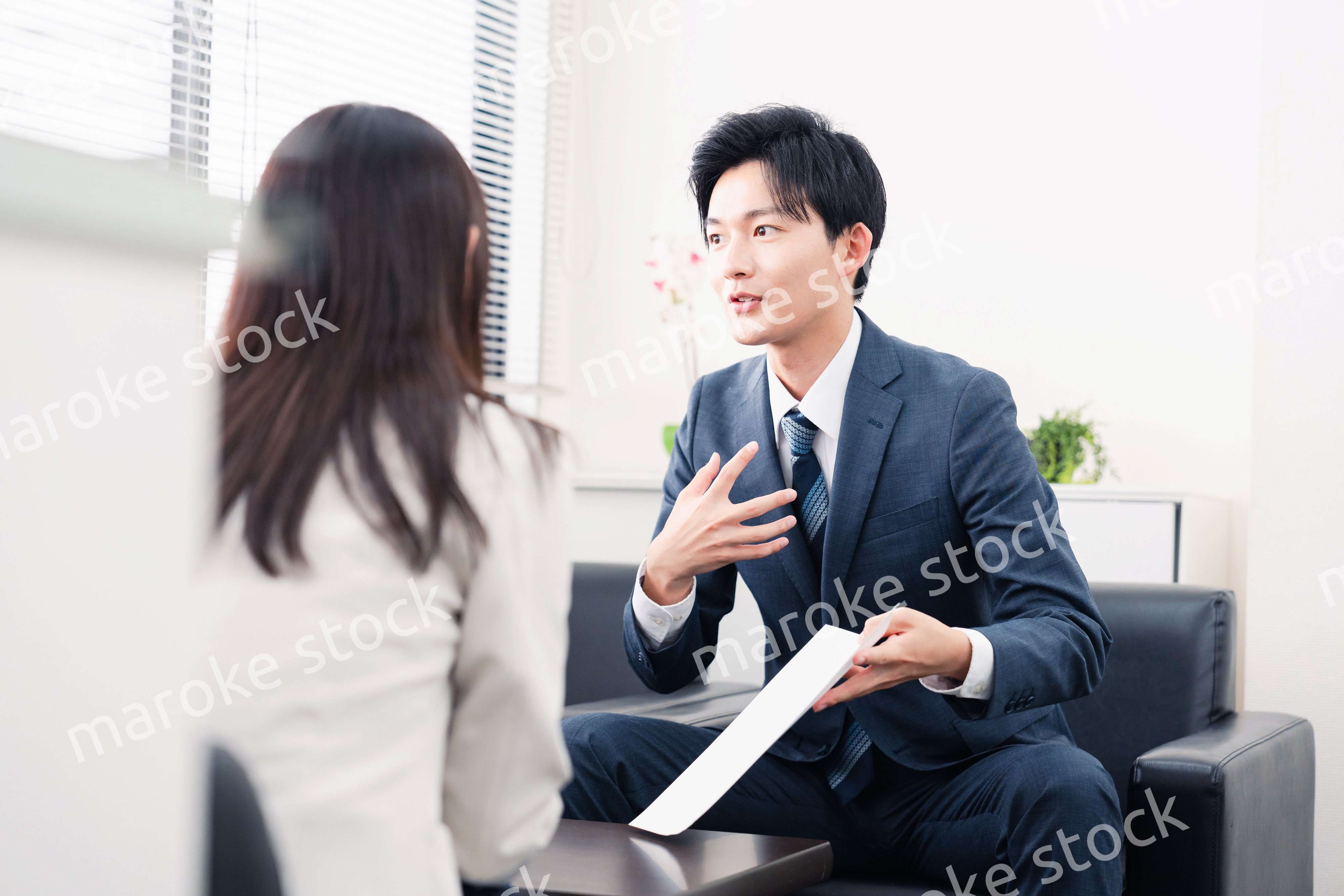 書類を提示する営業マン