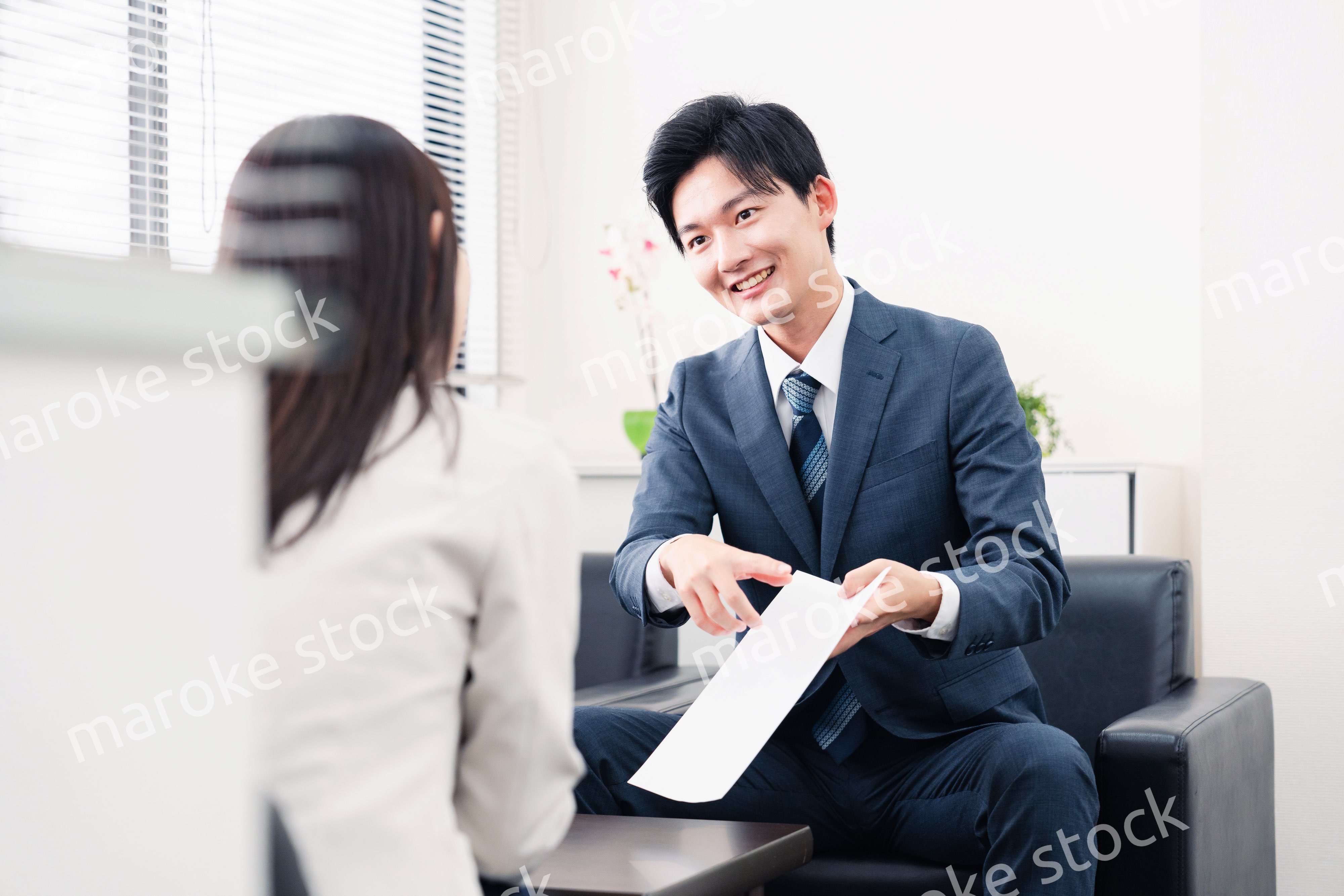 書類を提示する営業マン