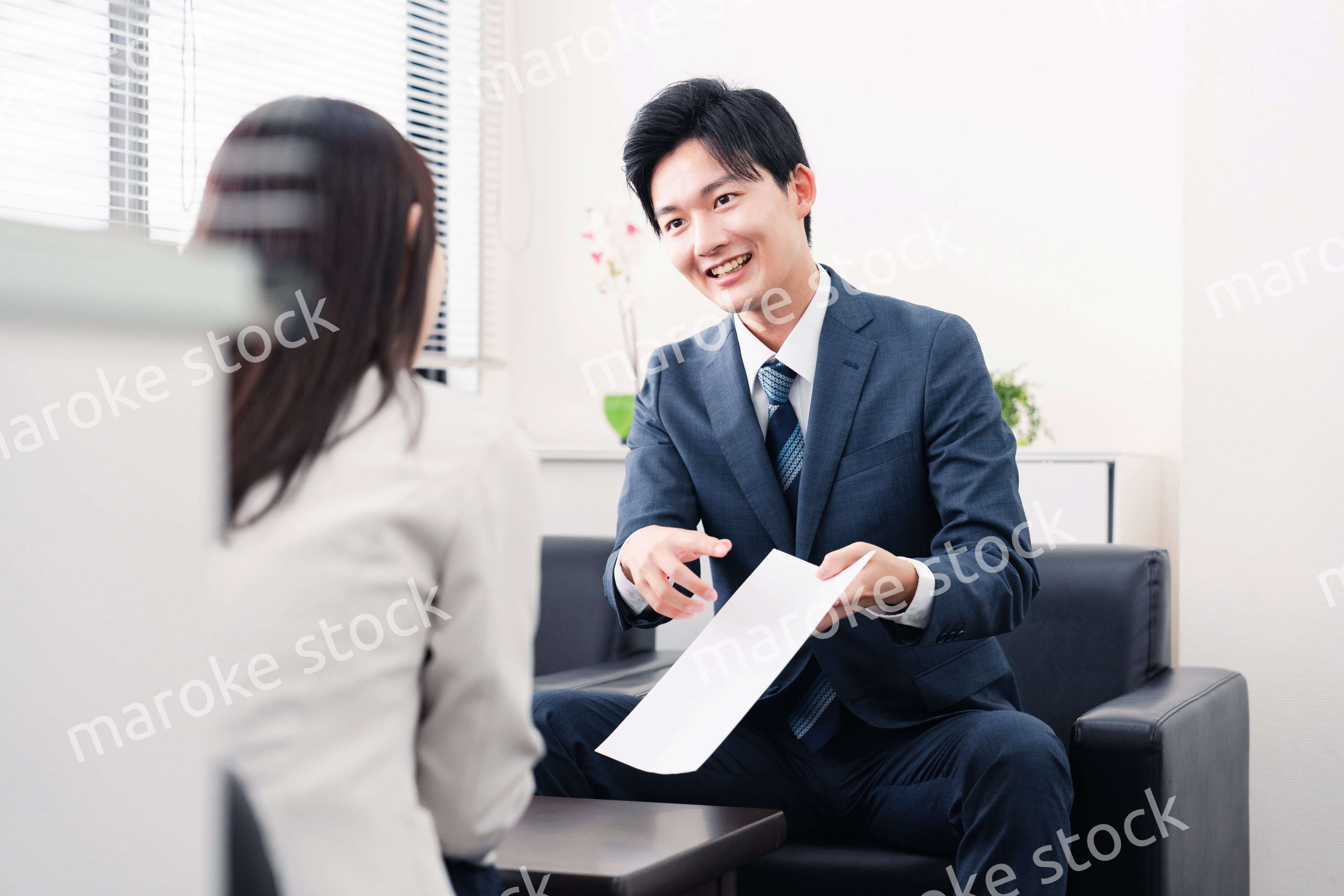 書類を提示する営業マン