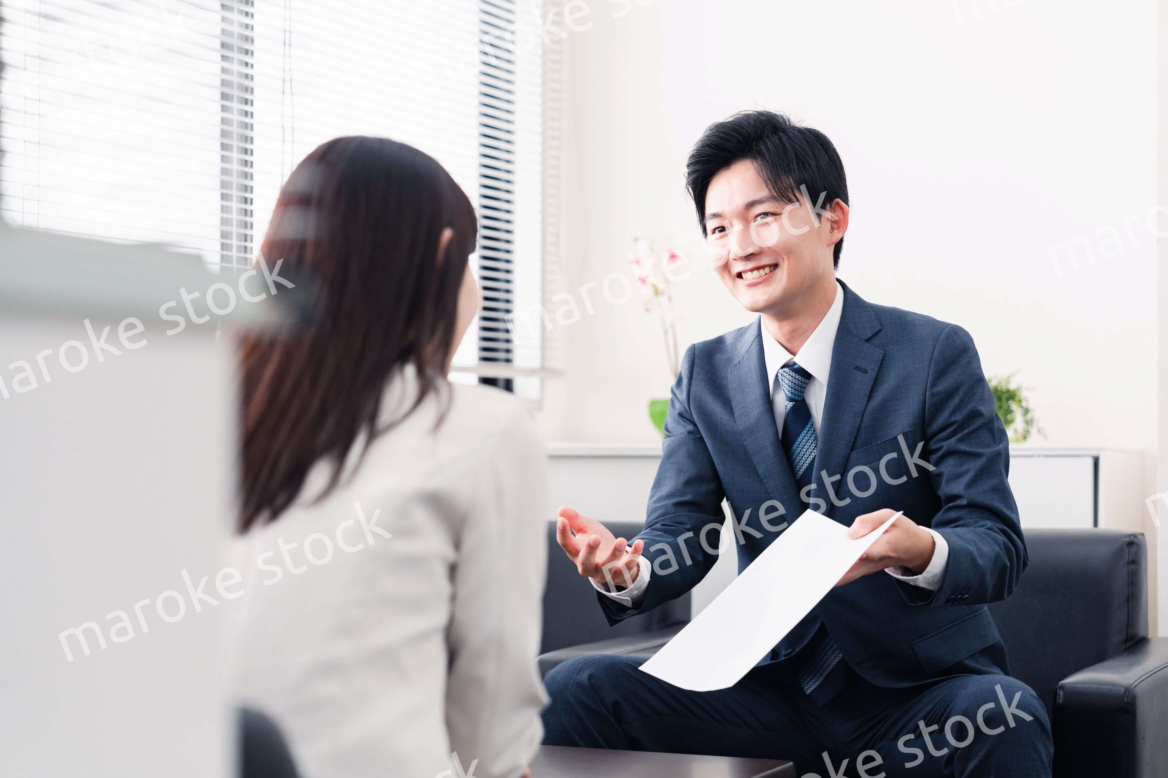 書類を提示する営業マン