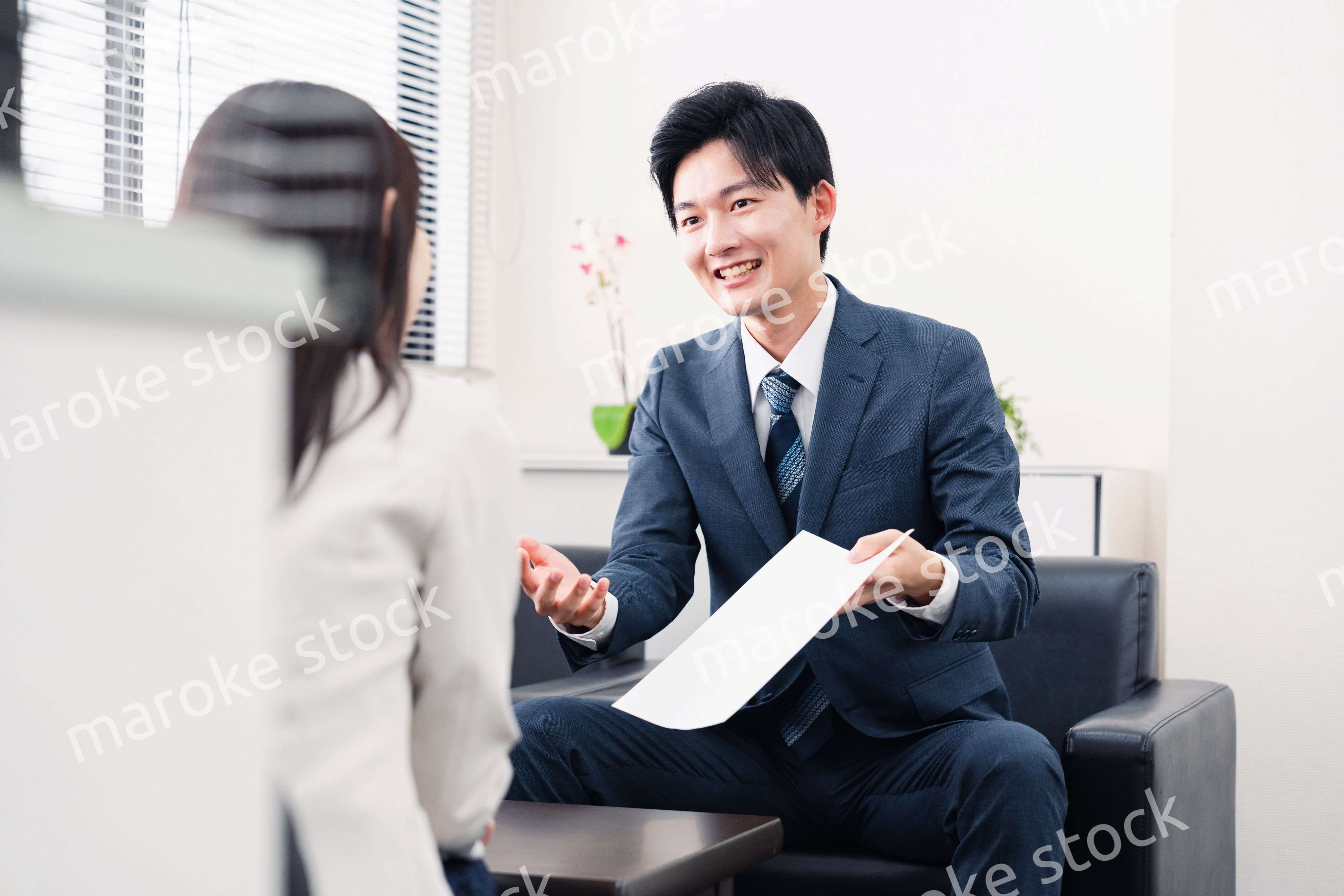 書類を提示する営業マン