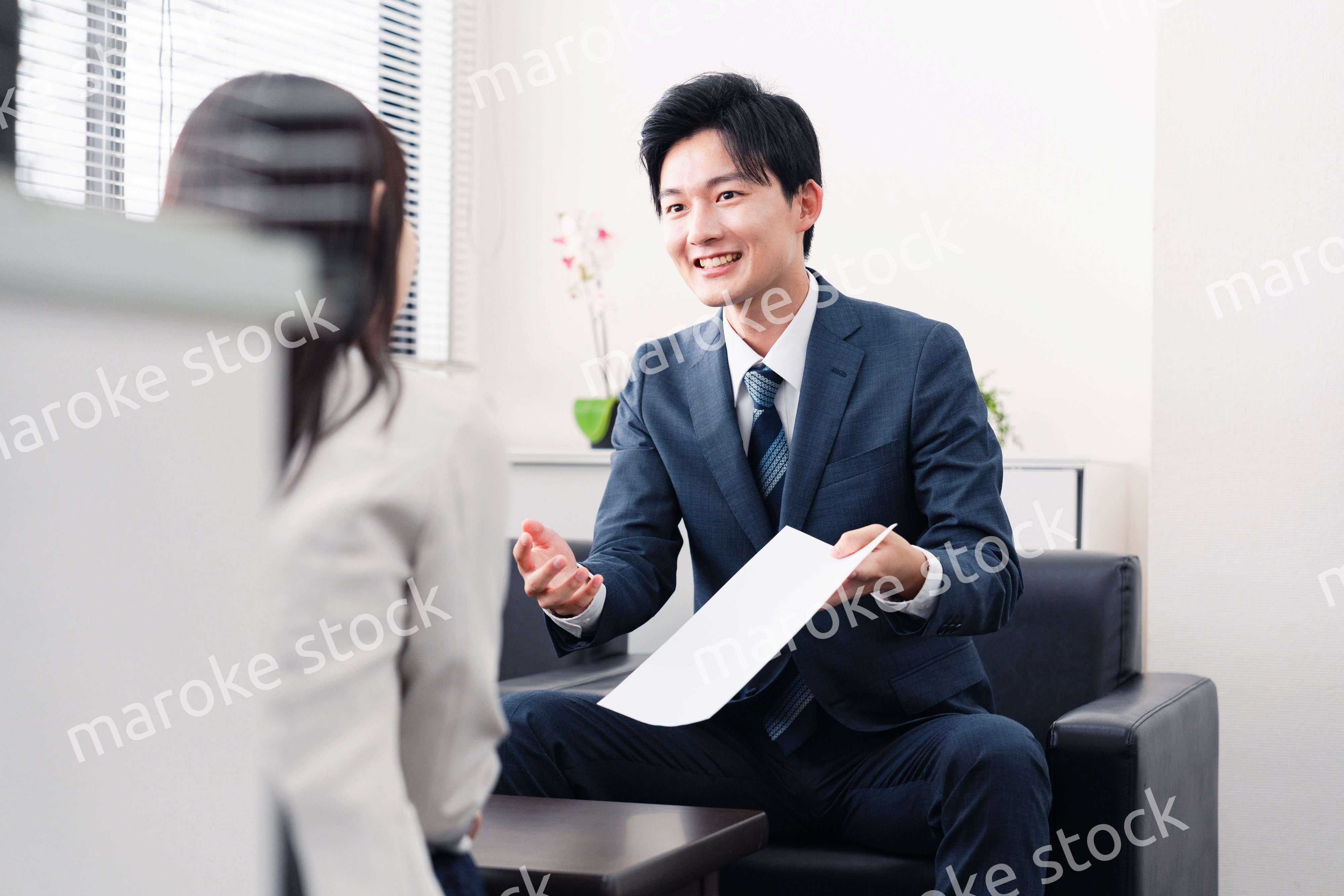 書類を提示する営業マン