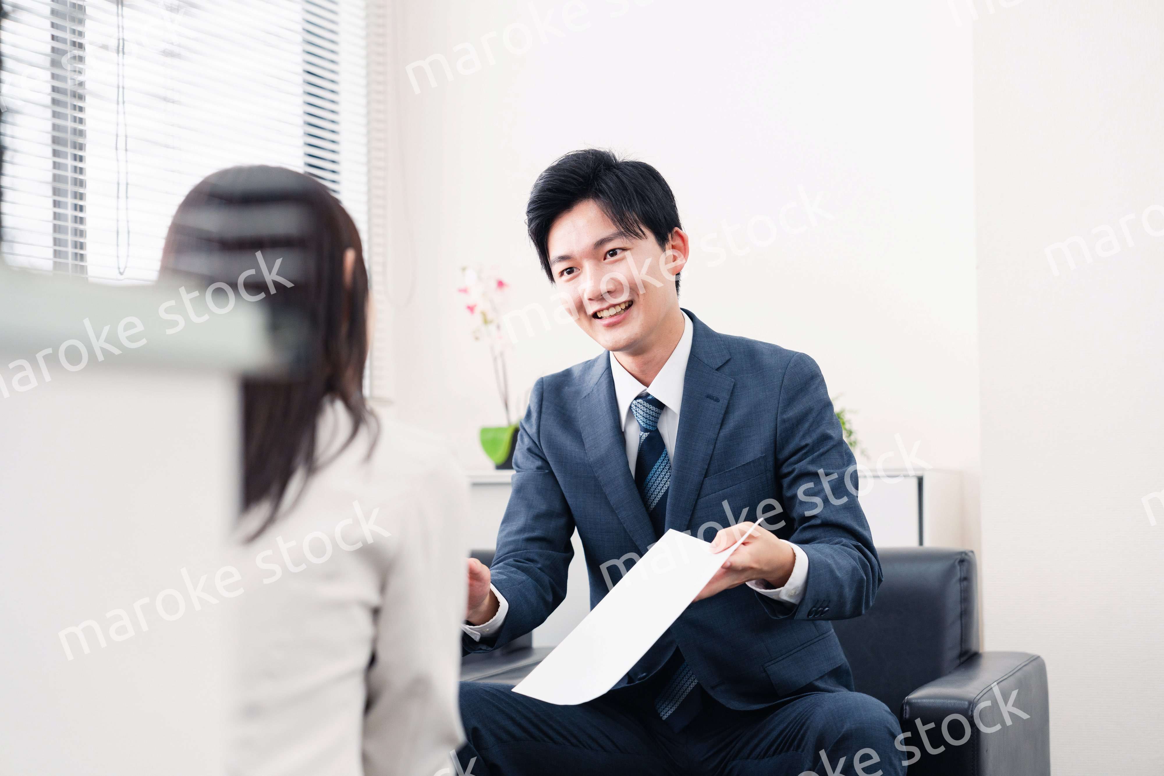 書類を提示する営業マン