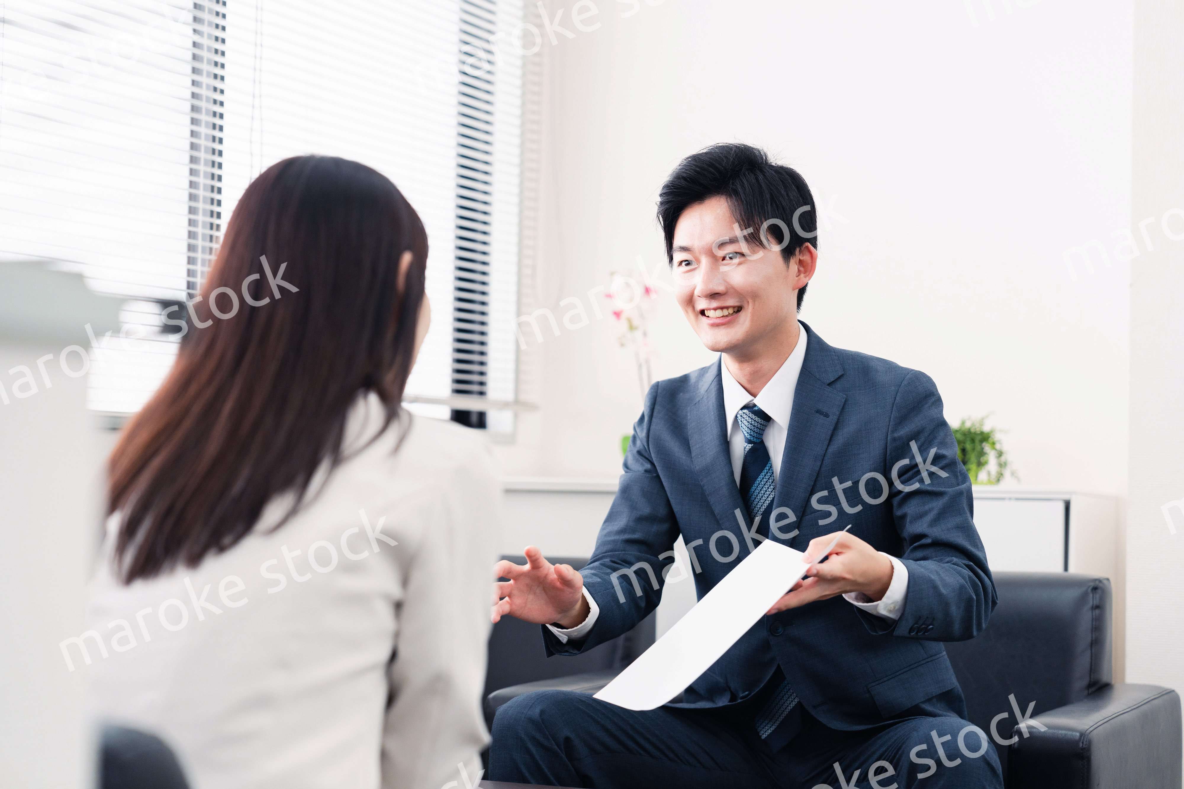 書類を提示する営業マン