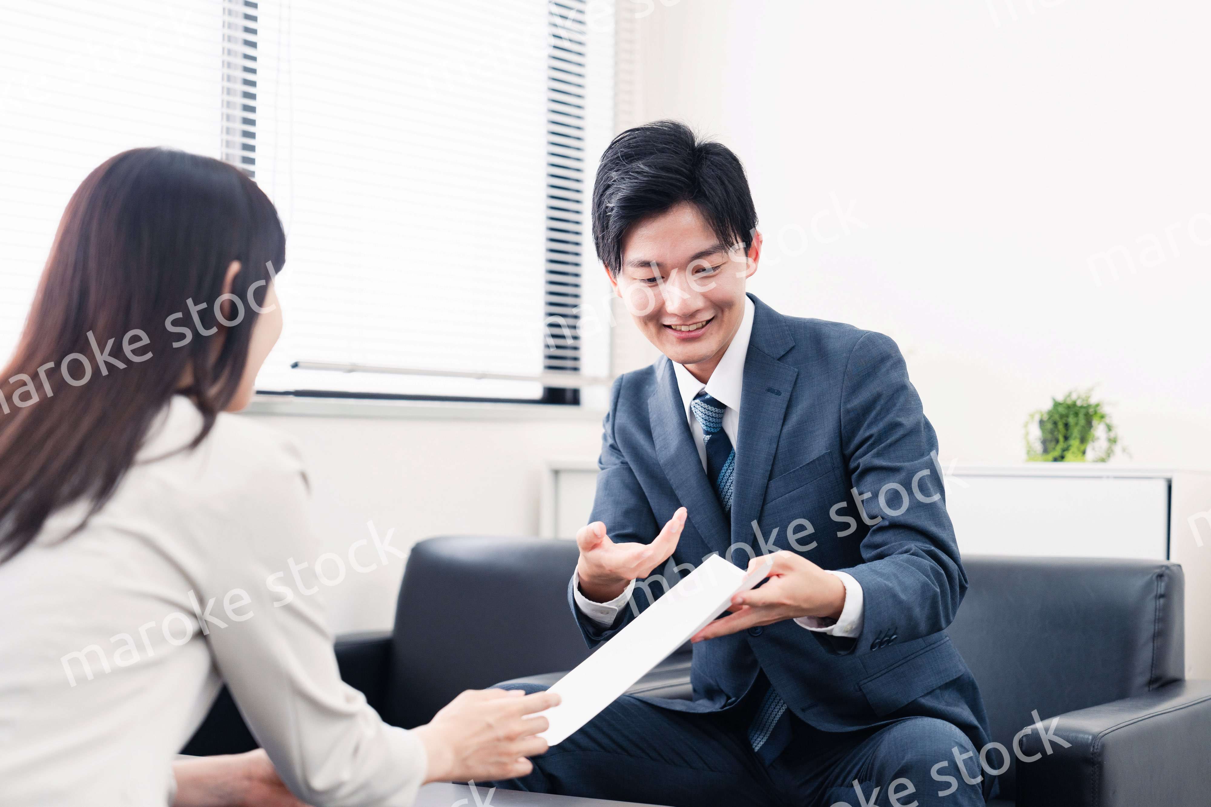 書類を提示する営業マン