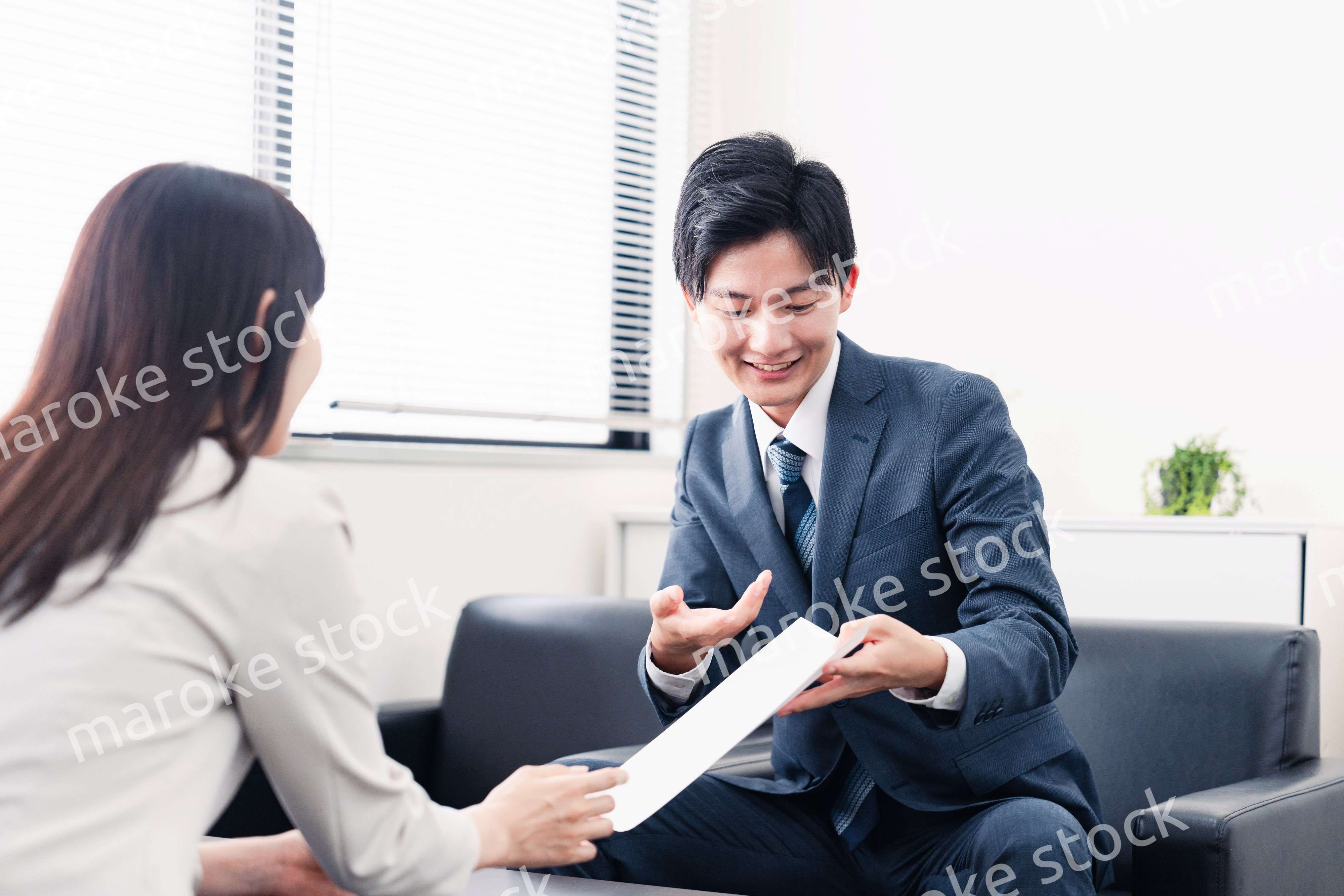 書類を提示する営業マン