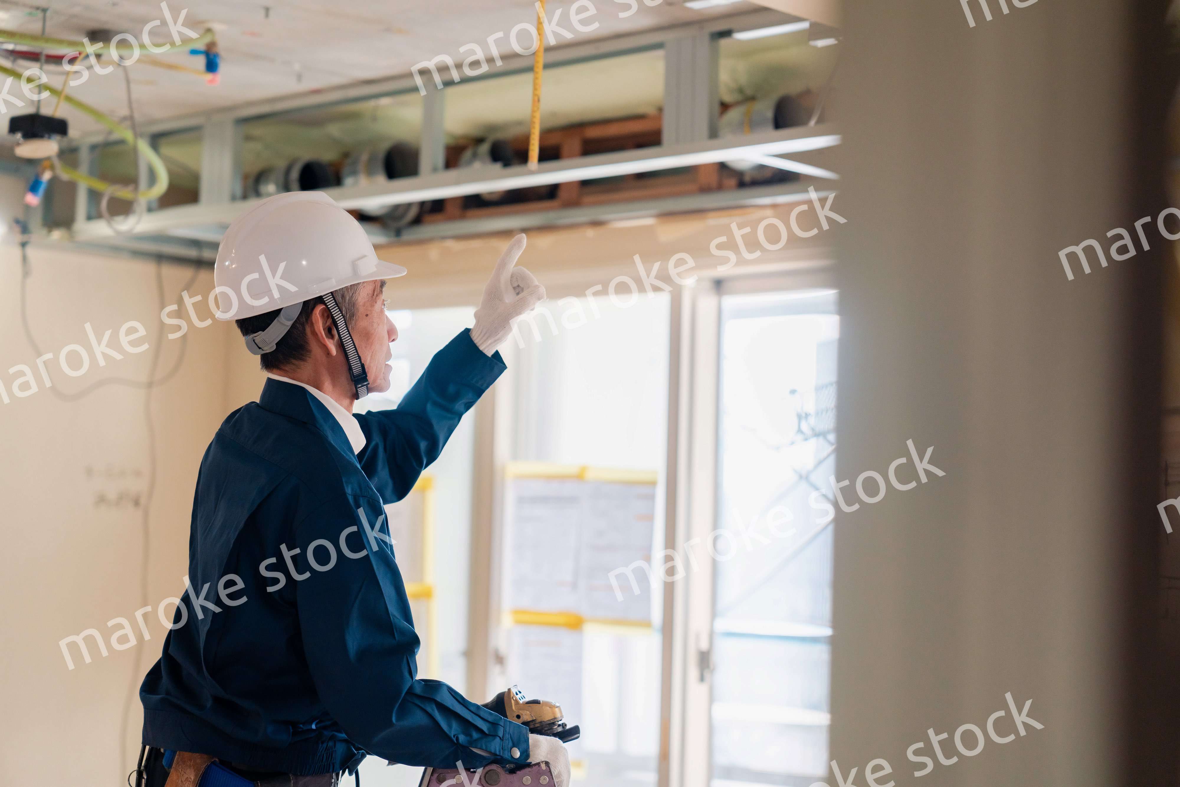 工事中の現場で指差し確認をする職人