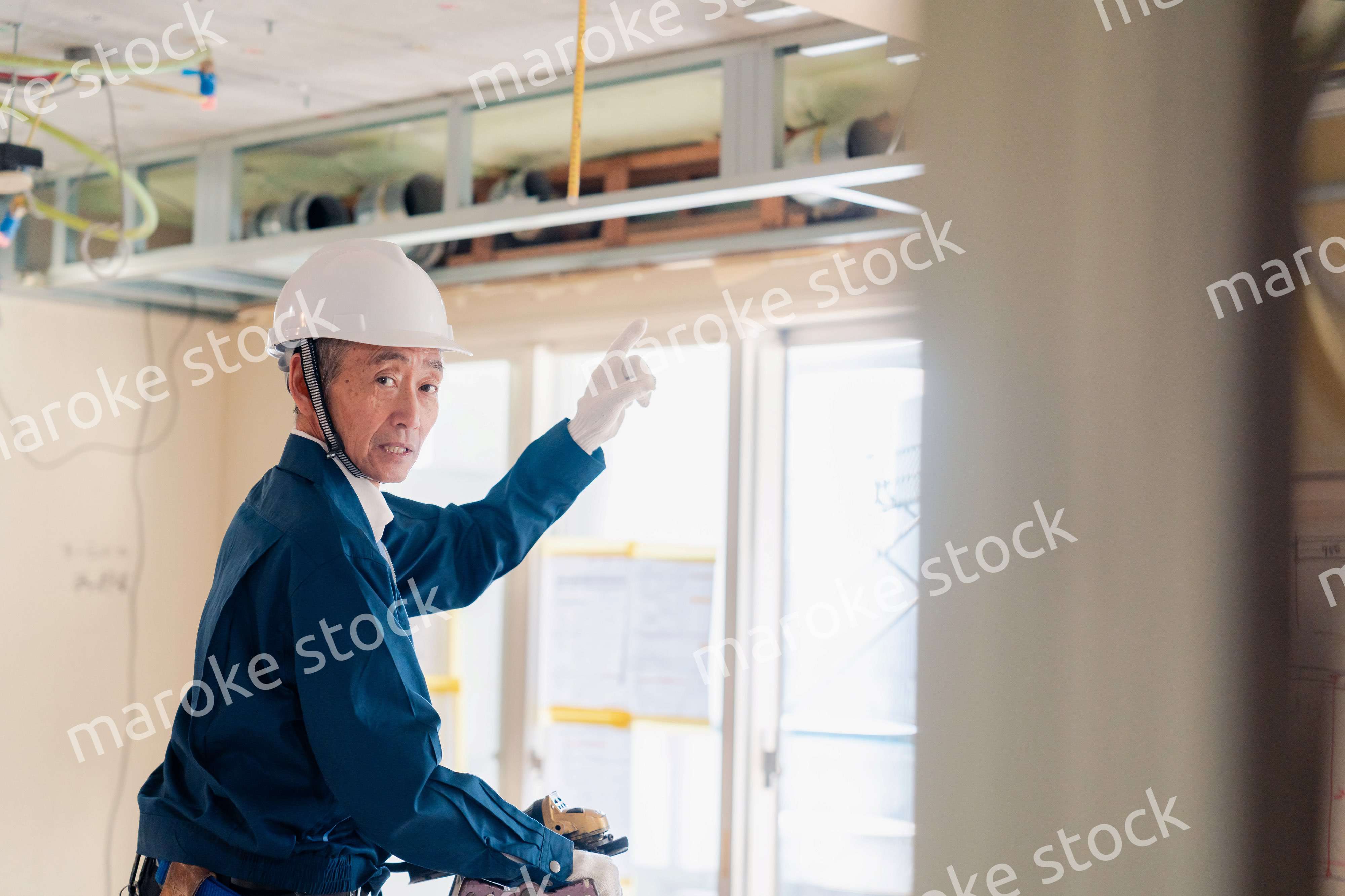 工事中の現場で指差し確認をする職人