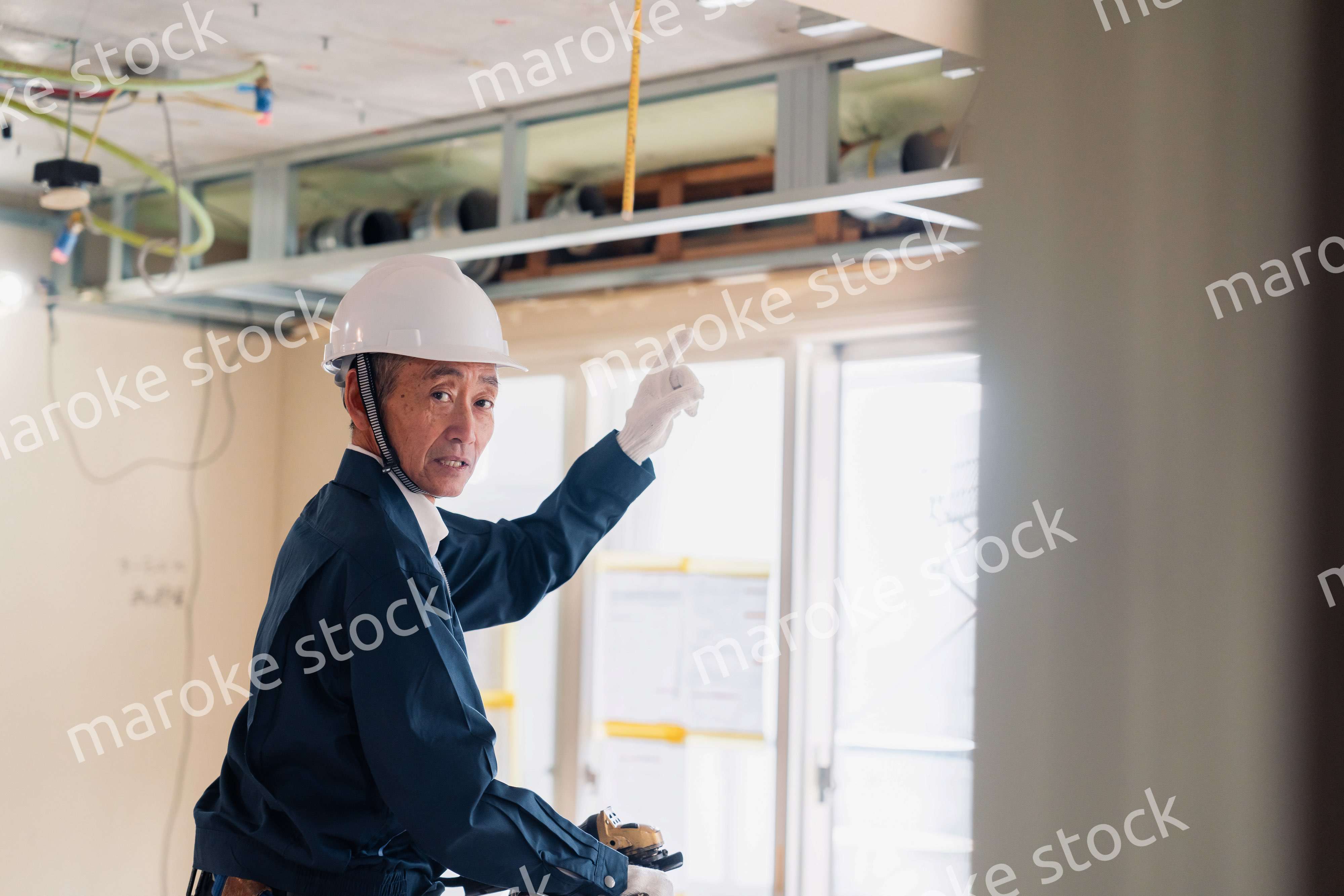 工事中の現場で指差し確認をする職人