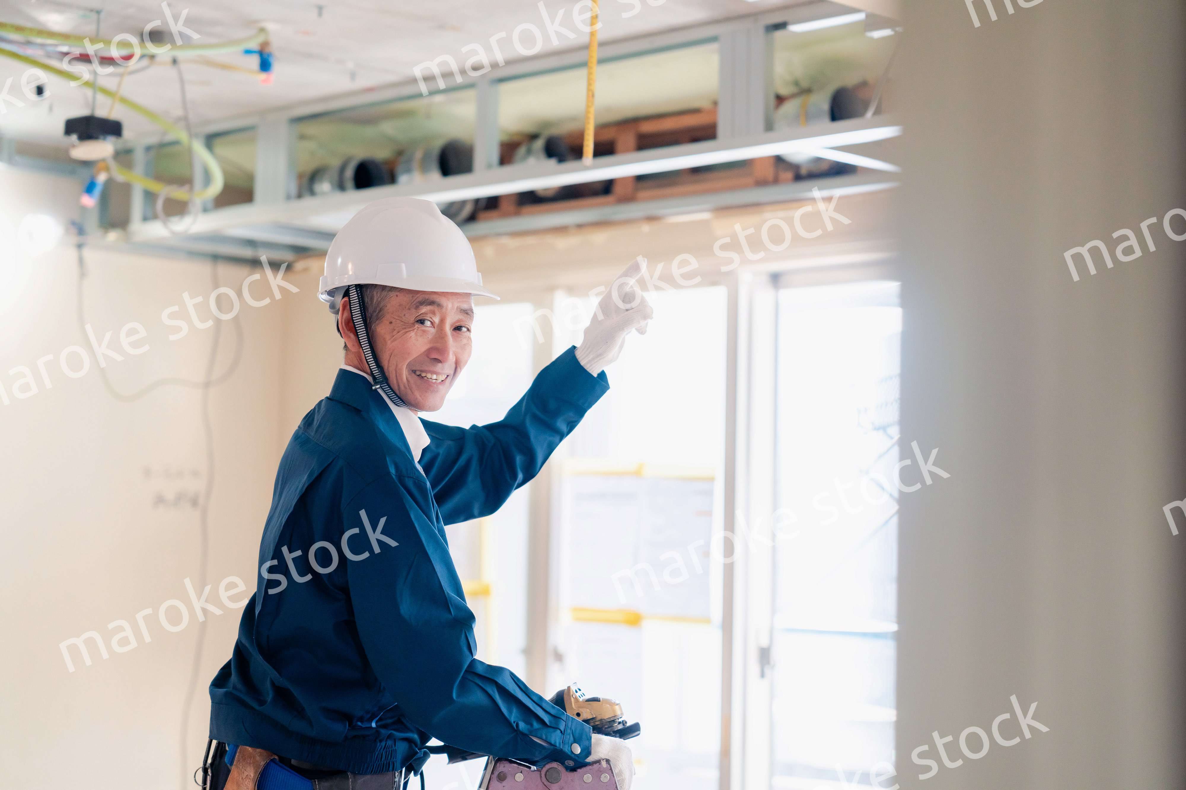 工事中の現場で指差し確認をする職人