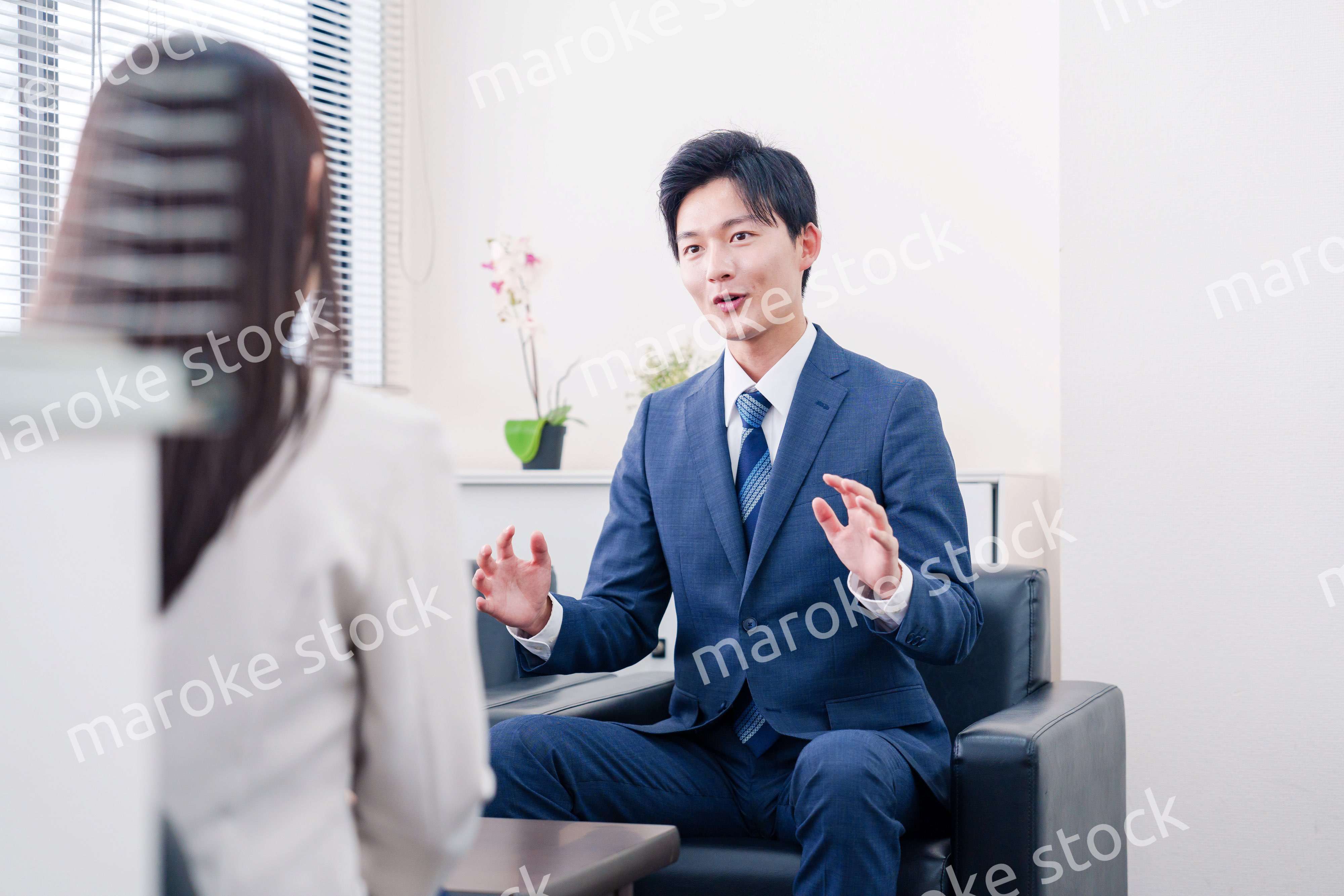 笑顔で得意先と商談をする営業マン