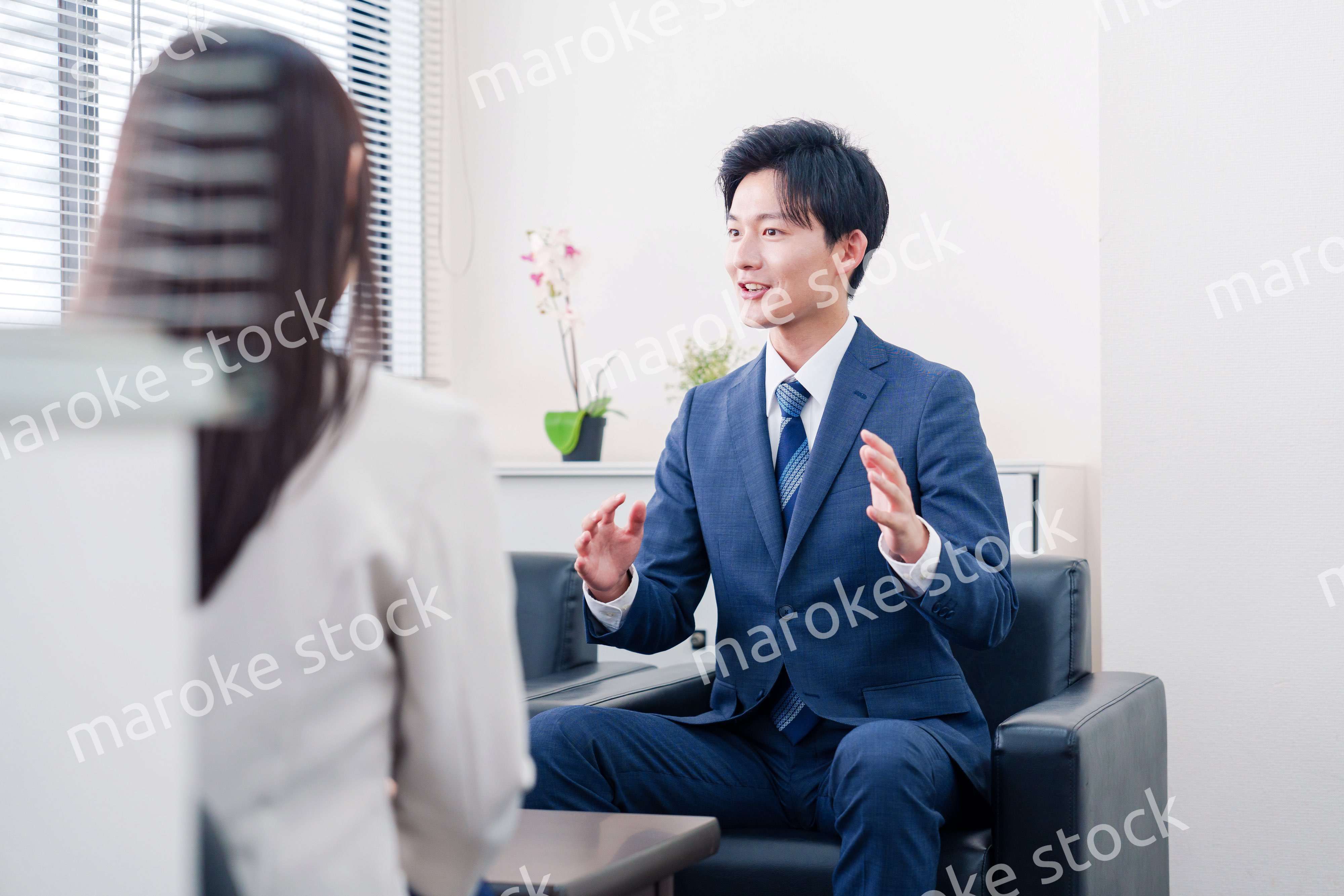 笑顔で得意先と商談をする営業マン