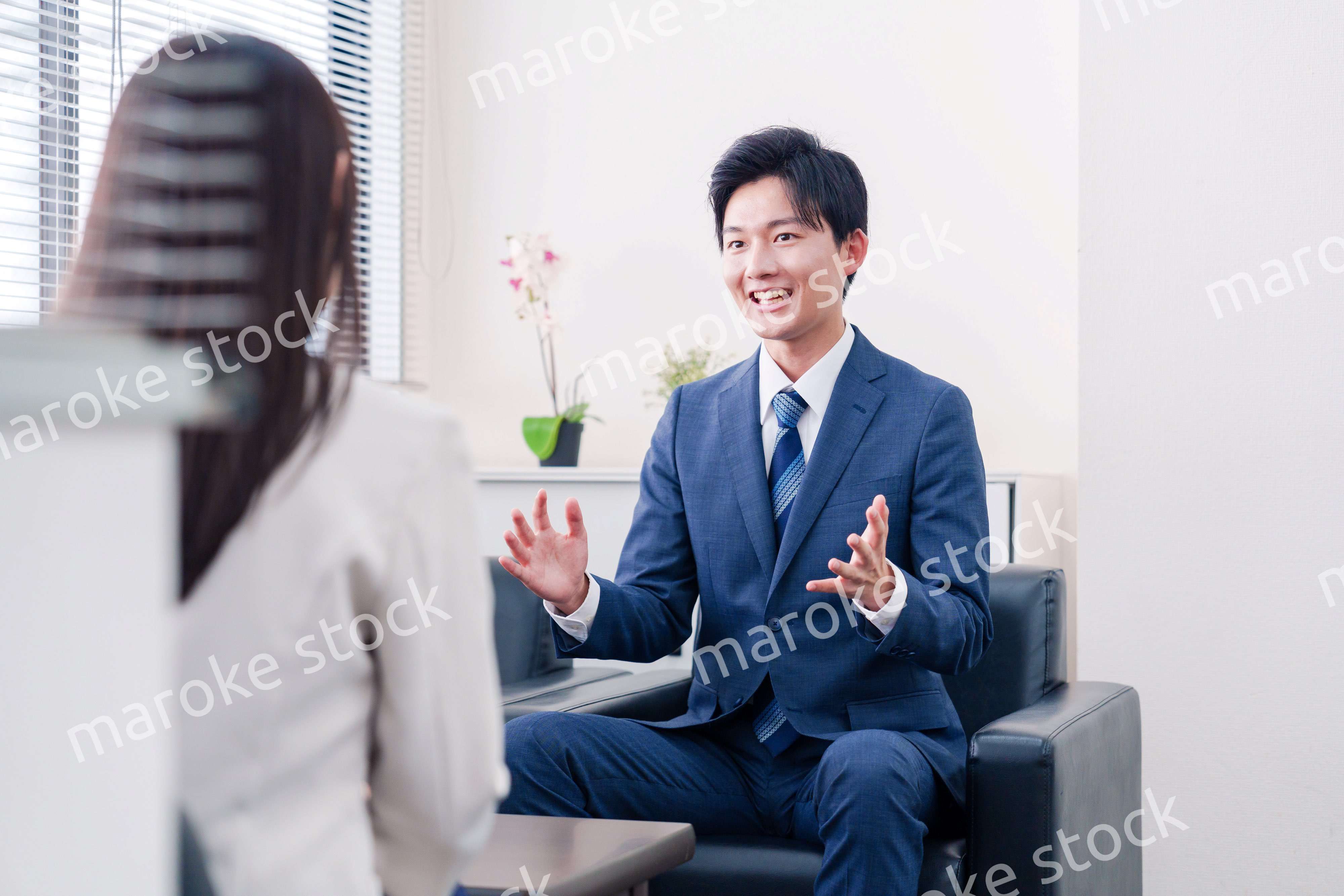 笑顔で得意先と商談をする営業マン