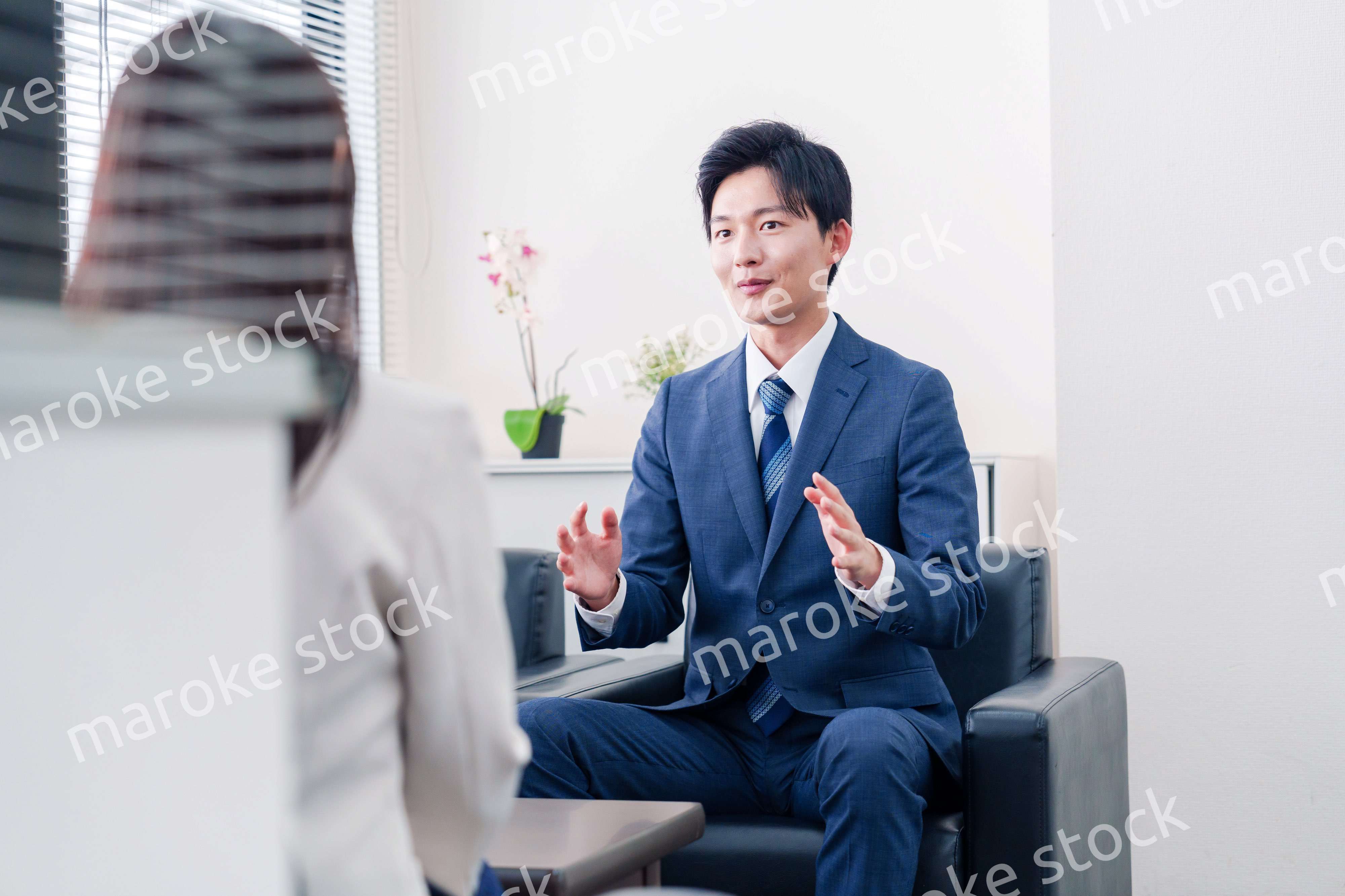 笑顔で得意先と商談をする営業マン