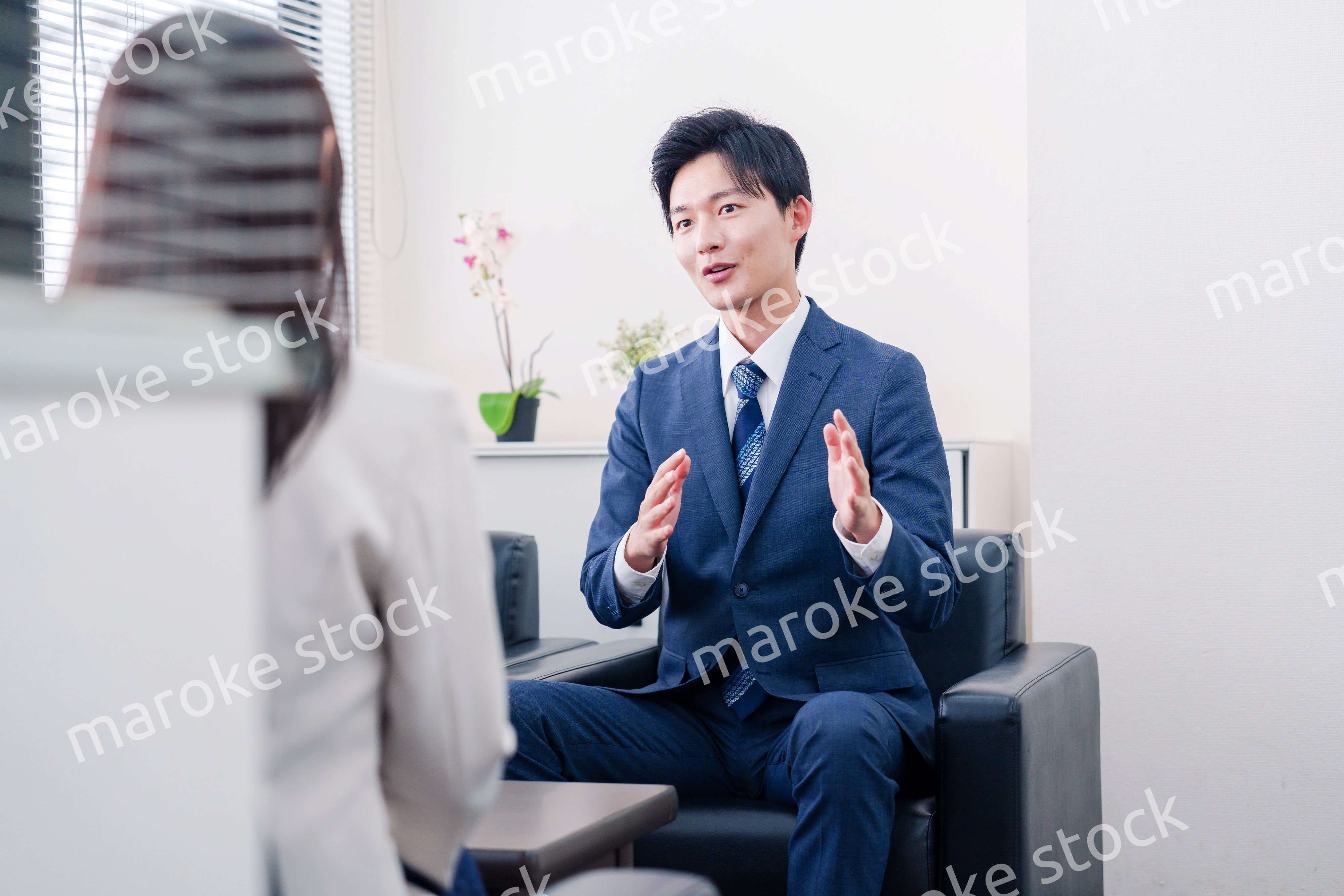 笑顔で得意先と商談をする営業マン