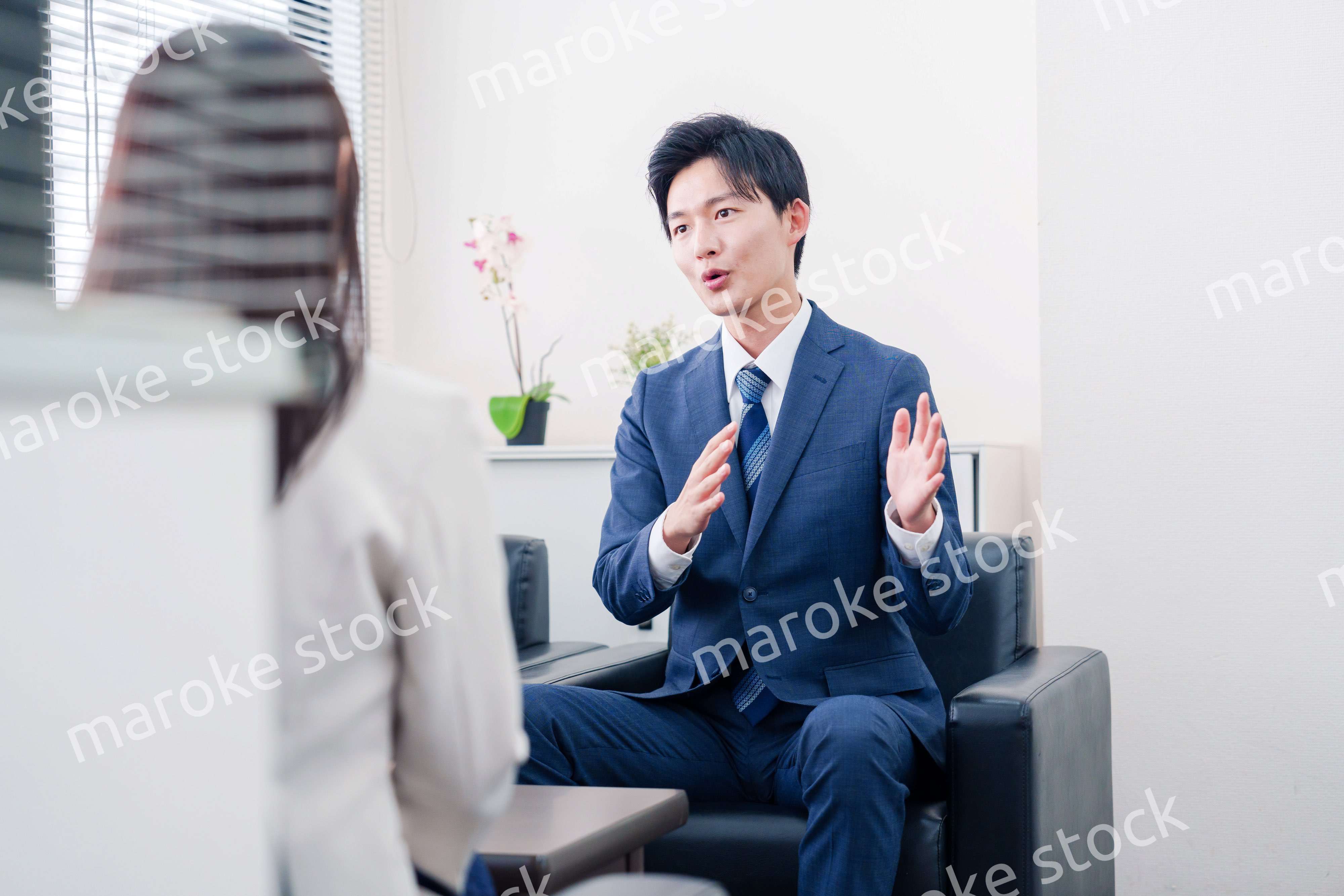 笑顔で得意先と商談をする営業マン