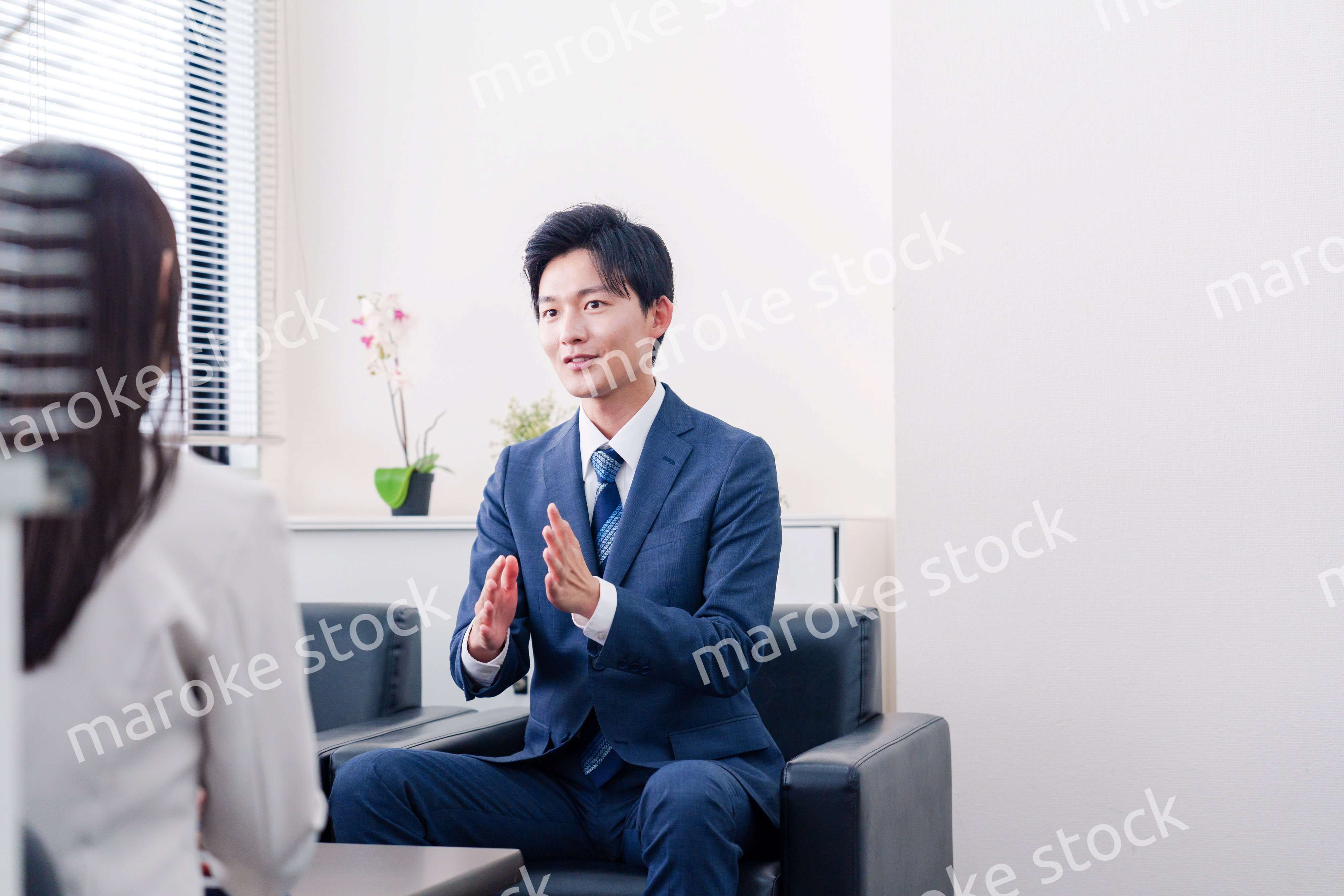 笑顔で得意先と商談をする営業マン