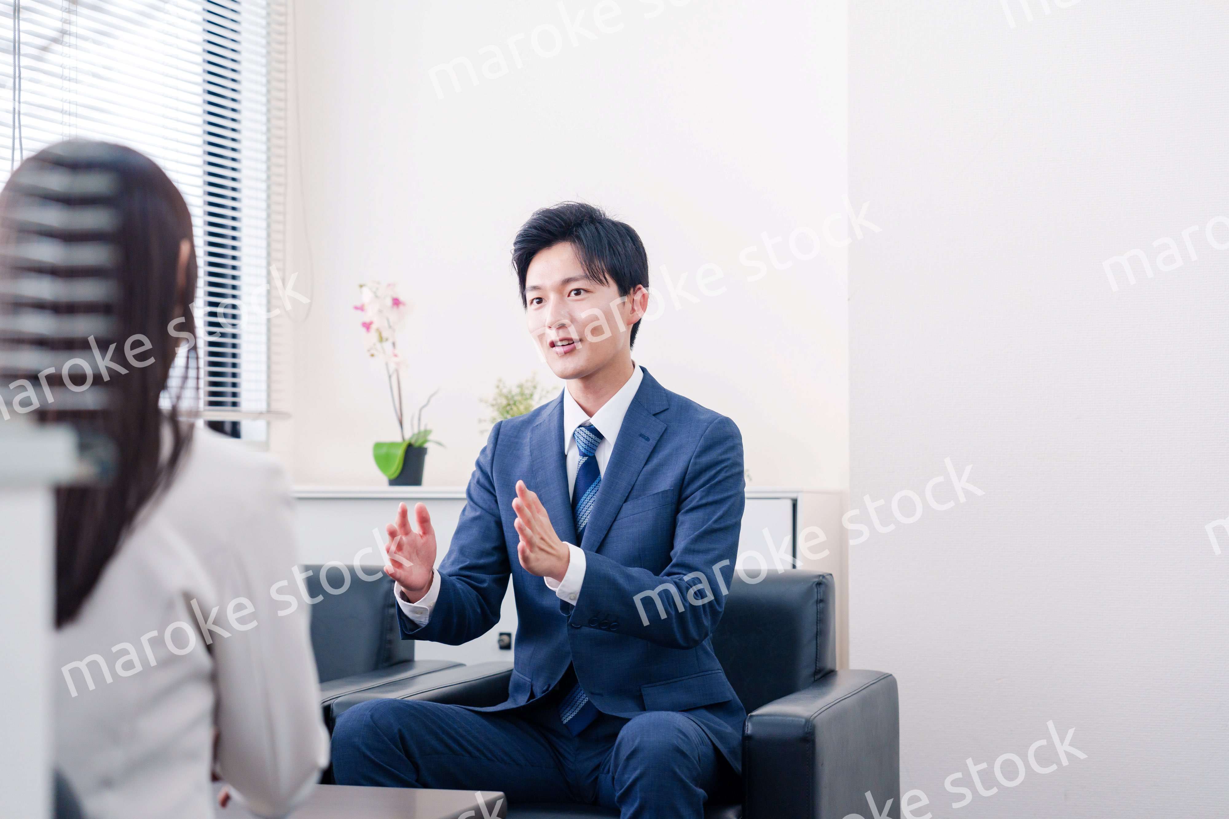 笑顔で得意先と商談をする営業マン