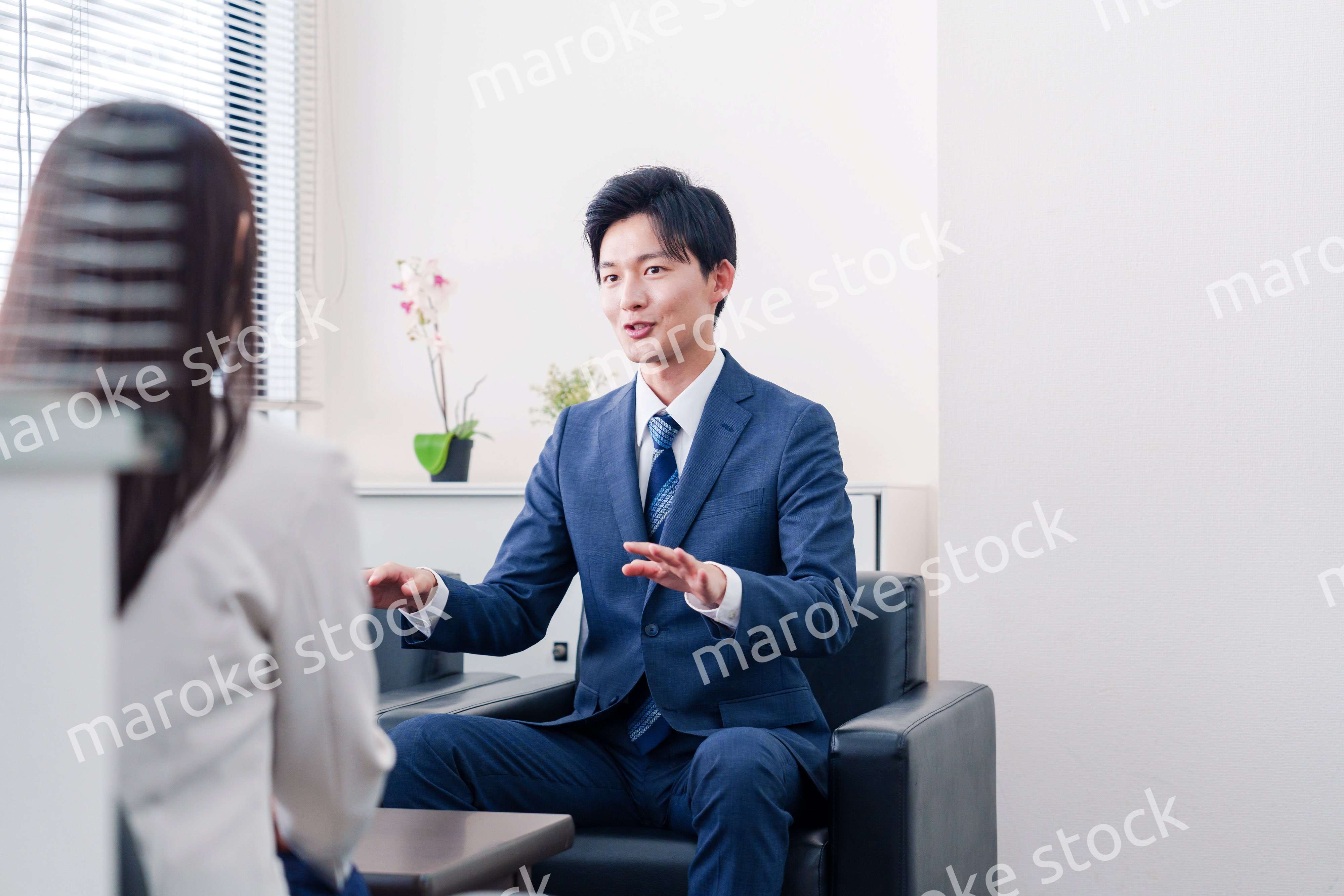 笑顔で得意先と商談をする営業マン