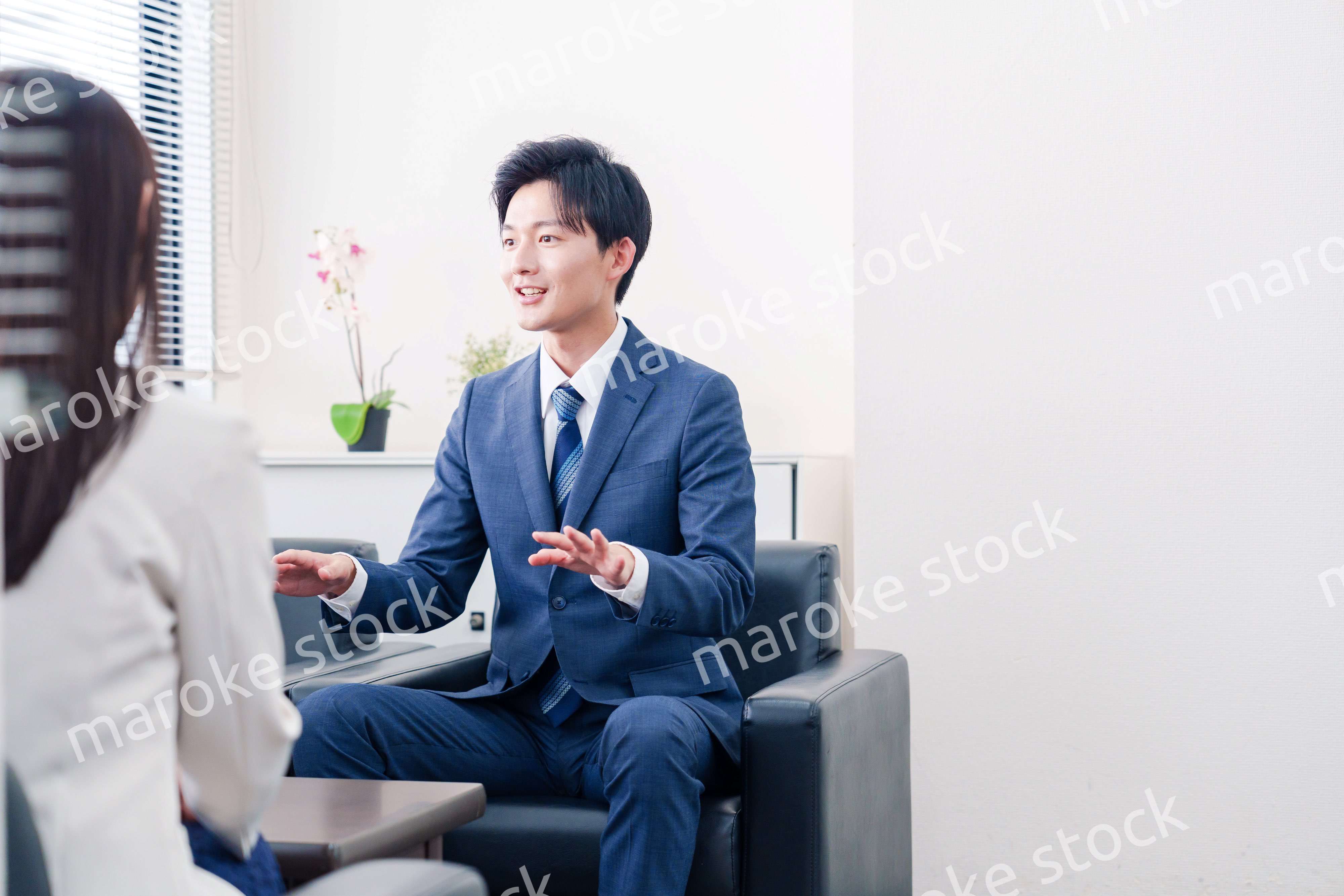 笑顔で得意先と商談をする営業マン