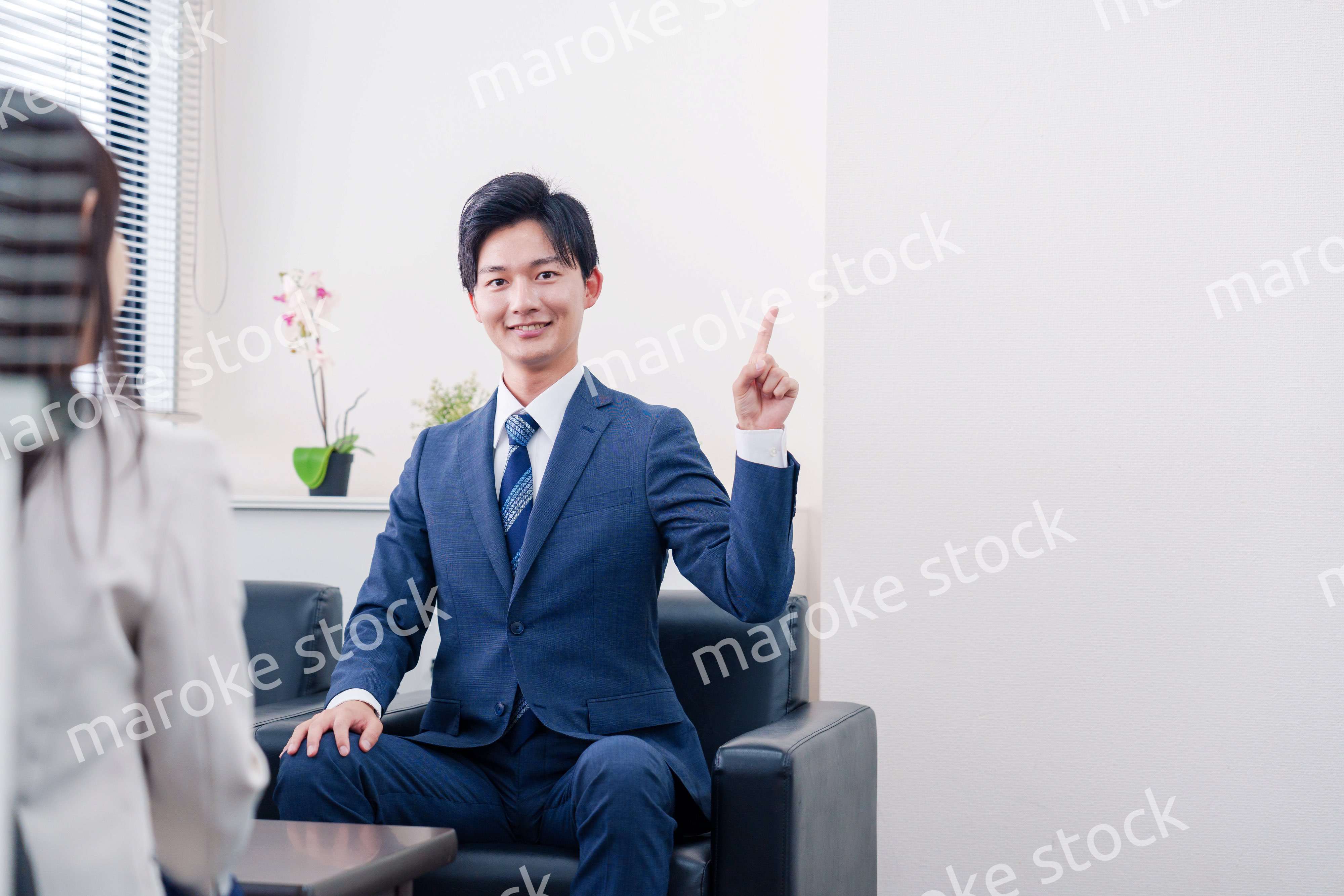 笑顔で得意先と商談をする営業マン