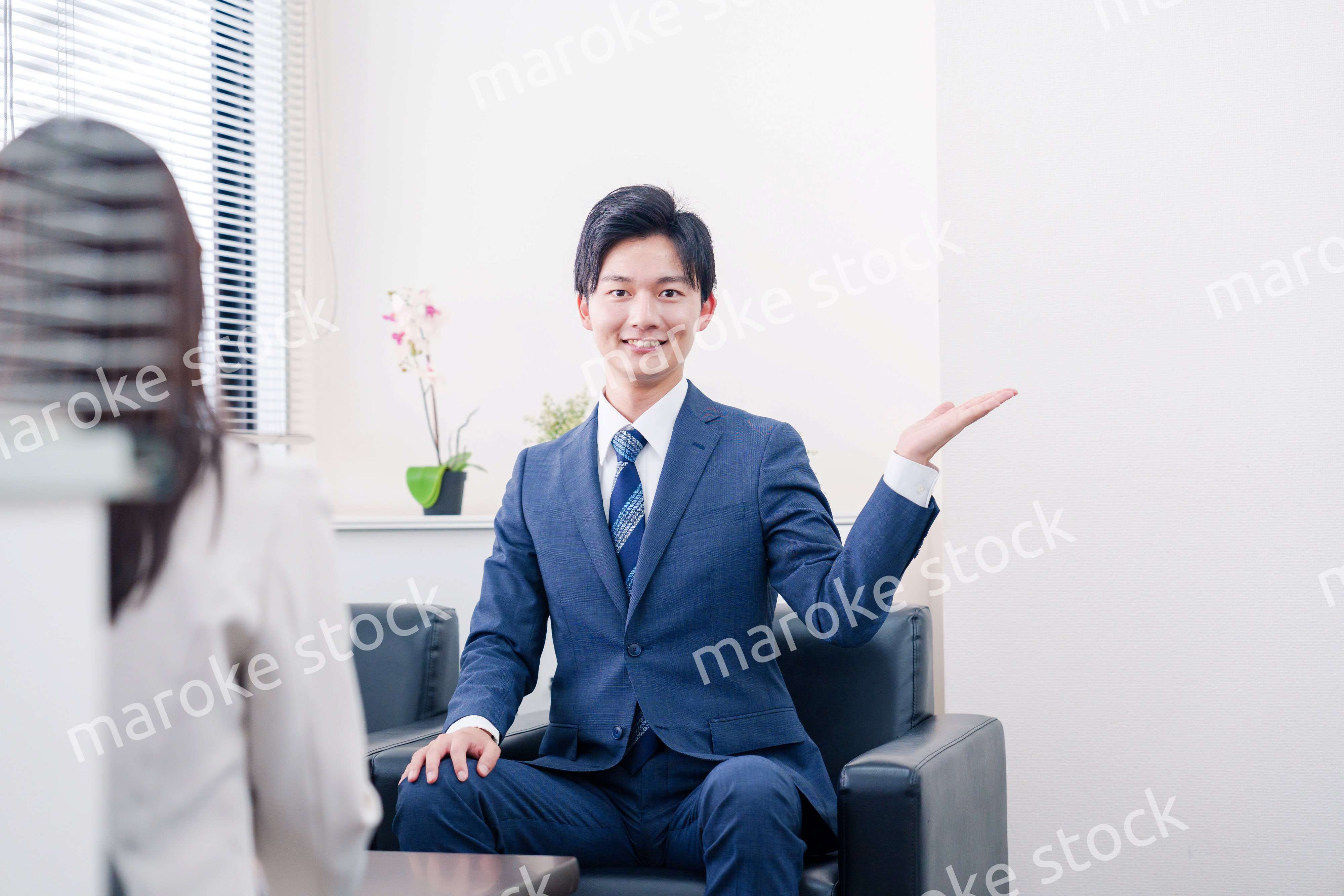 笑顔で得意先と商談をする営業マン