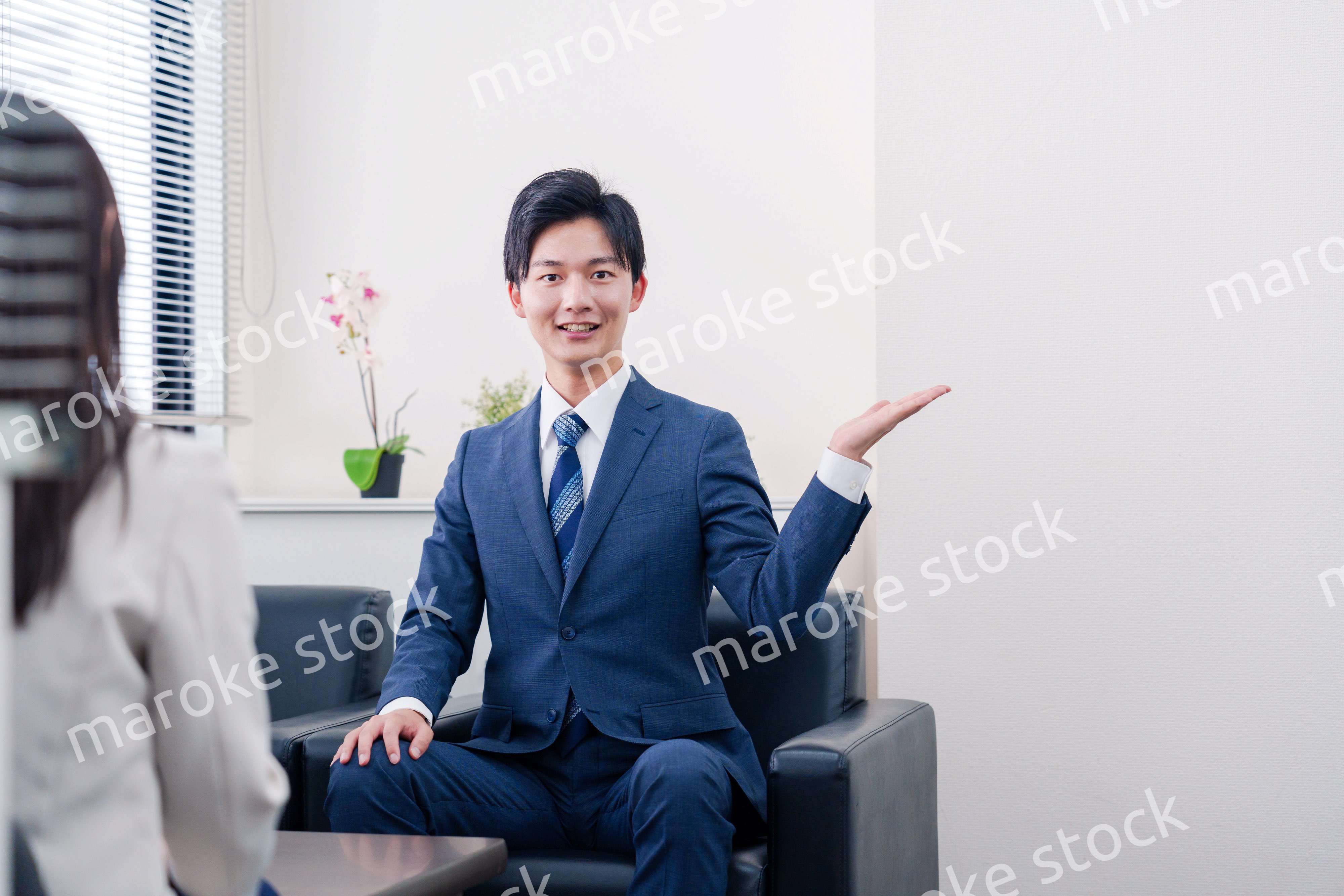 笑顔で得意先と商談をする営業マン