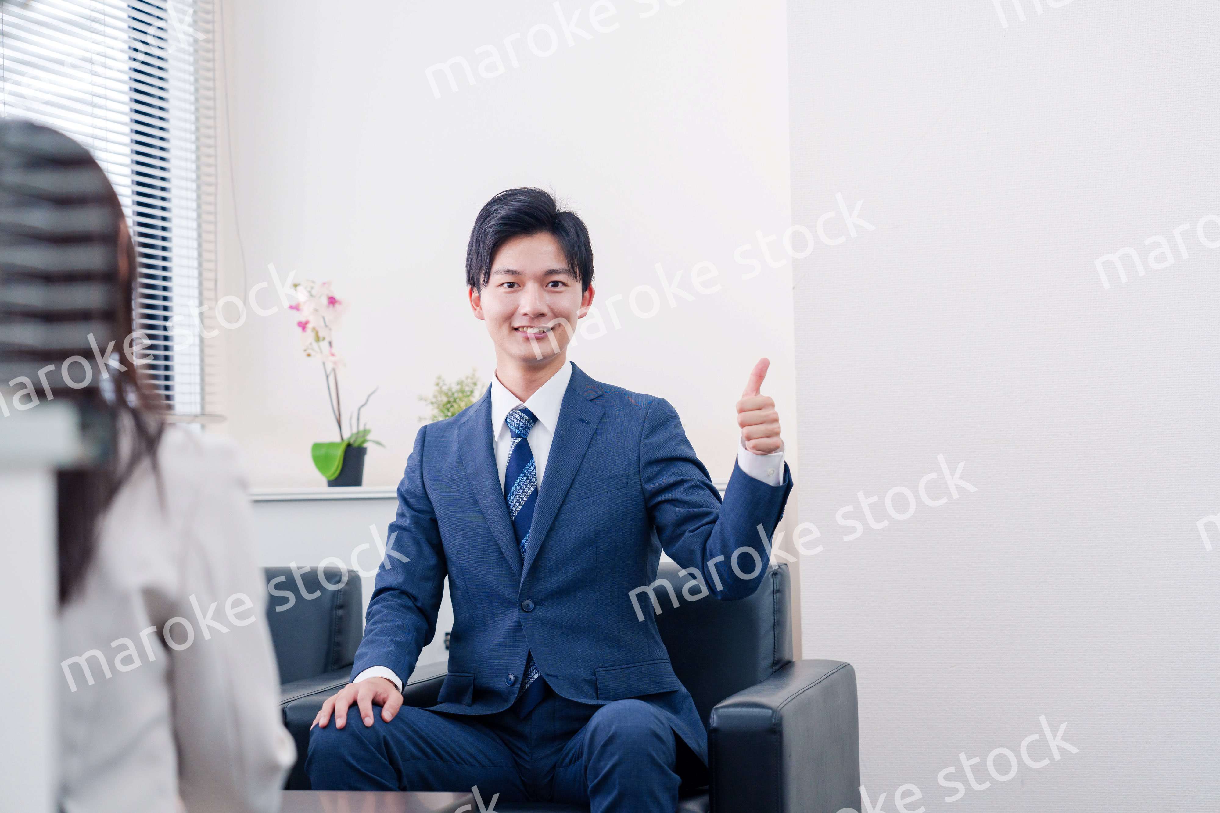 笑顔で得意先と商談をする営業マン