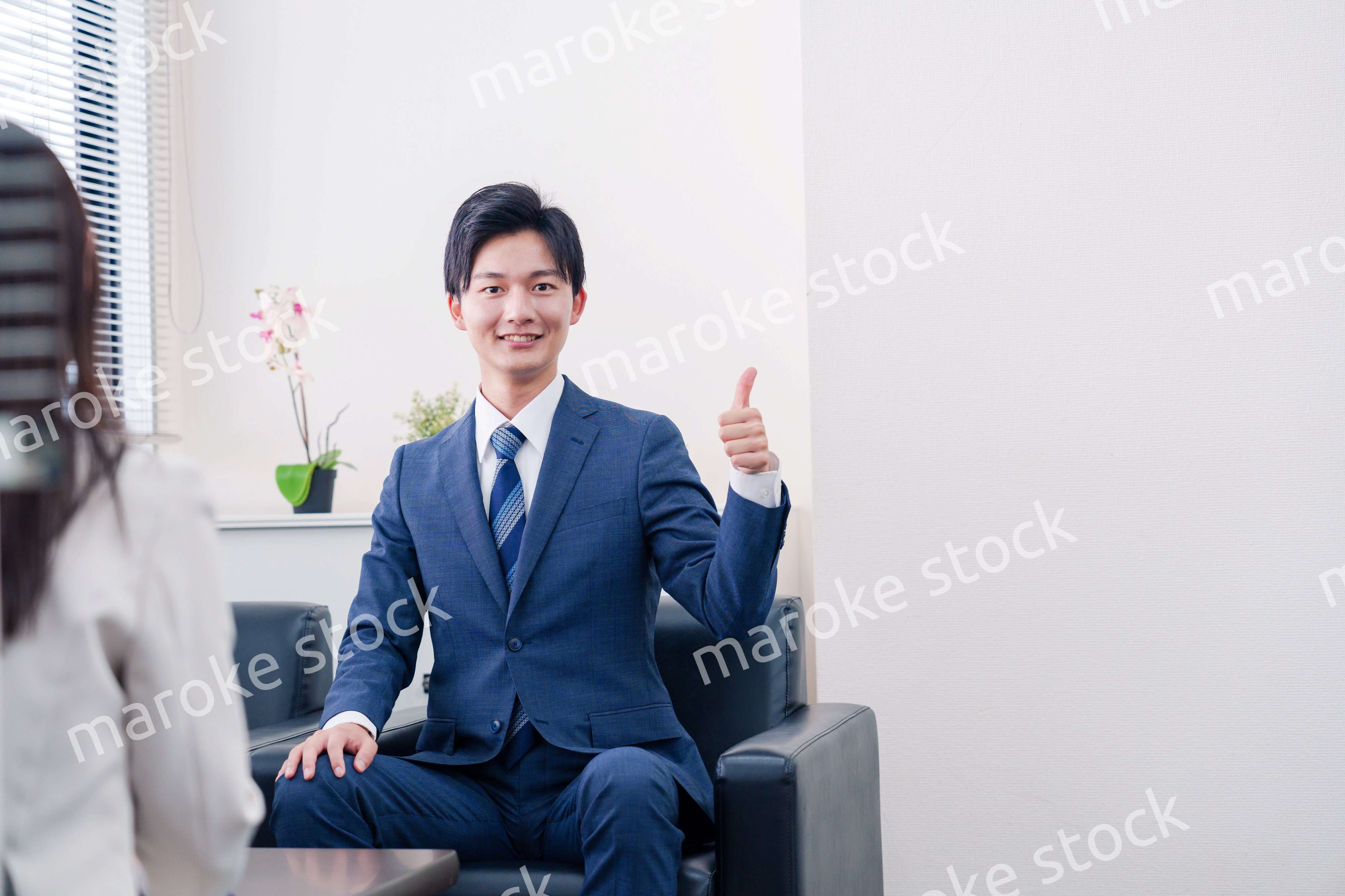 笑顔で得意先と商談をする営業マン