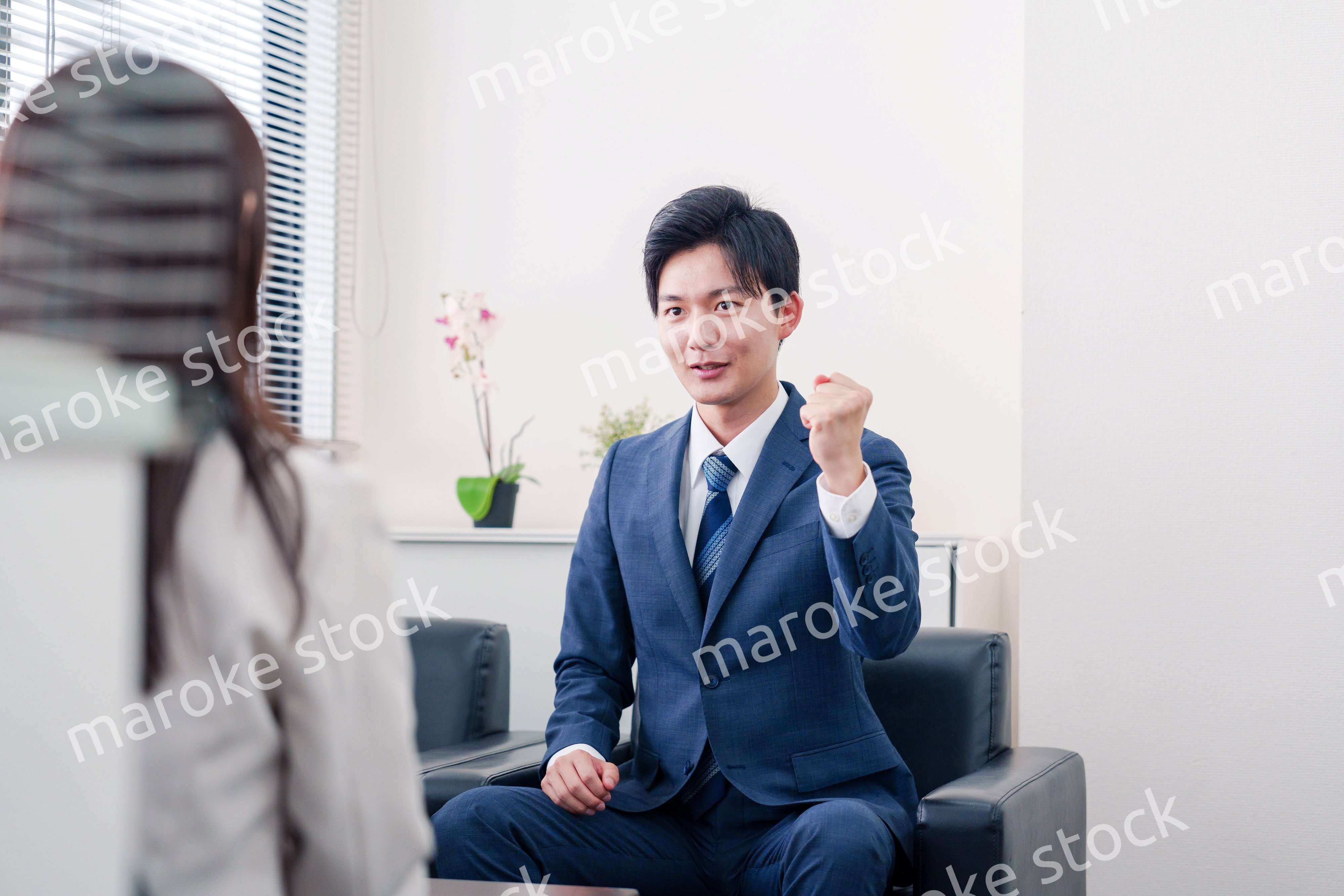 笑顔で得意先と商談をする営業マン