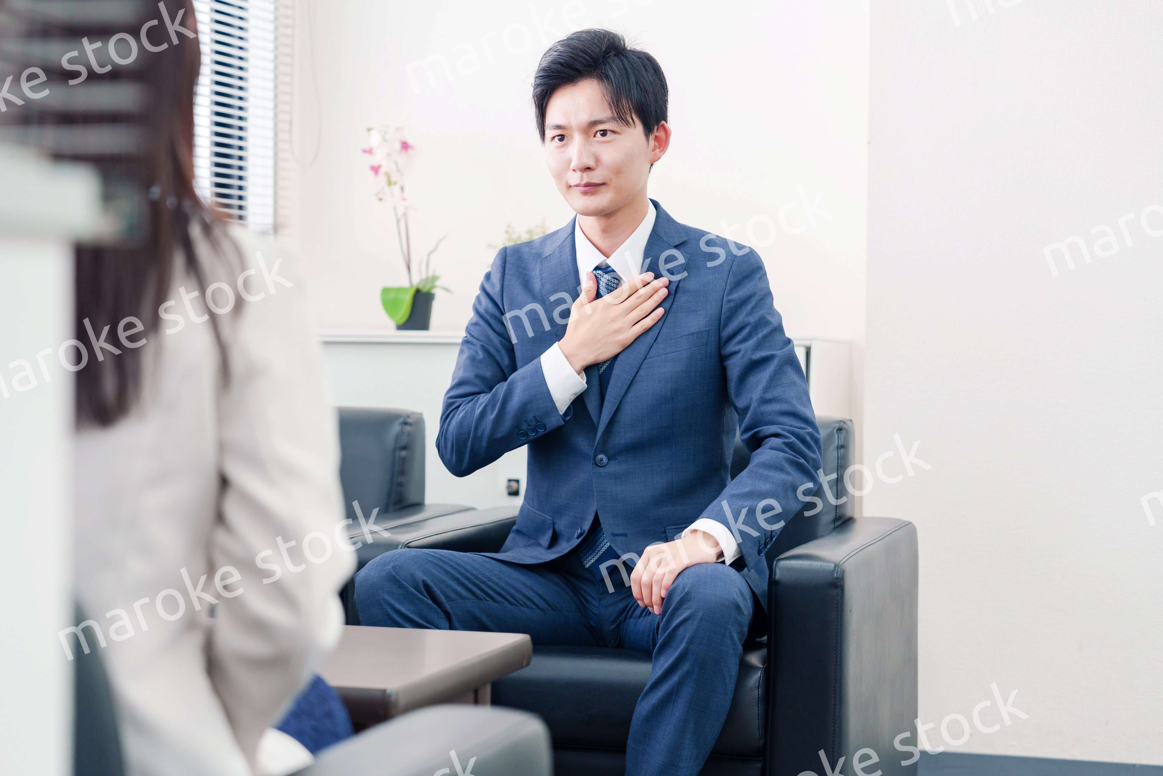 笑顔で得意先と商談をする営業マン