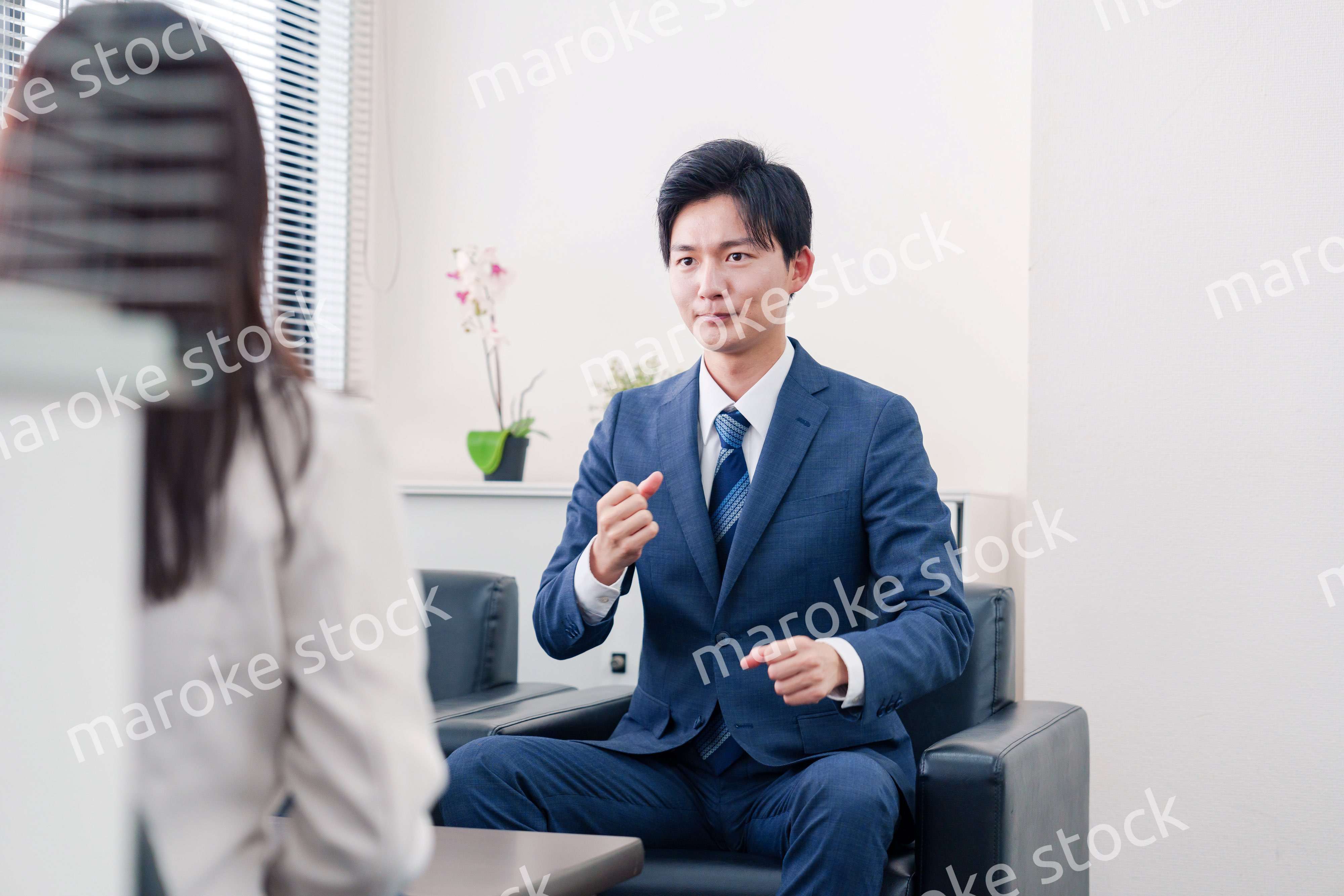 笑顔で得意先と商談をする営業マン