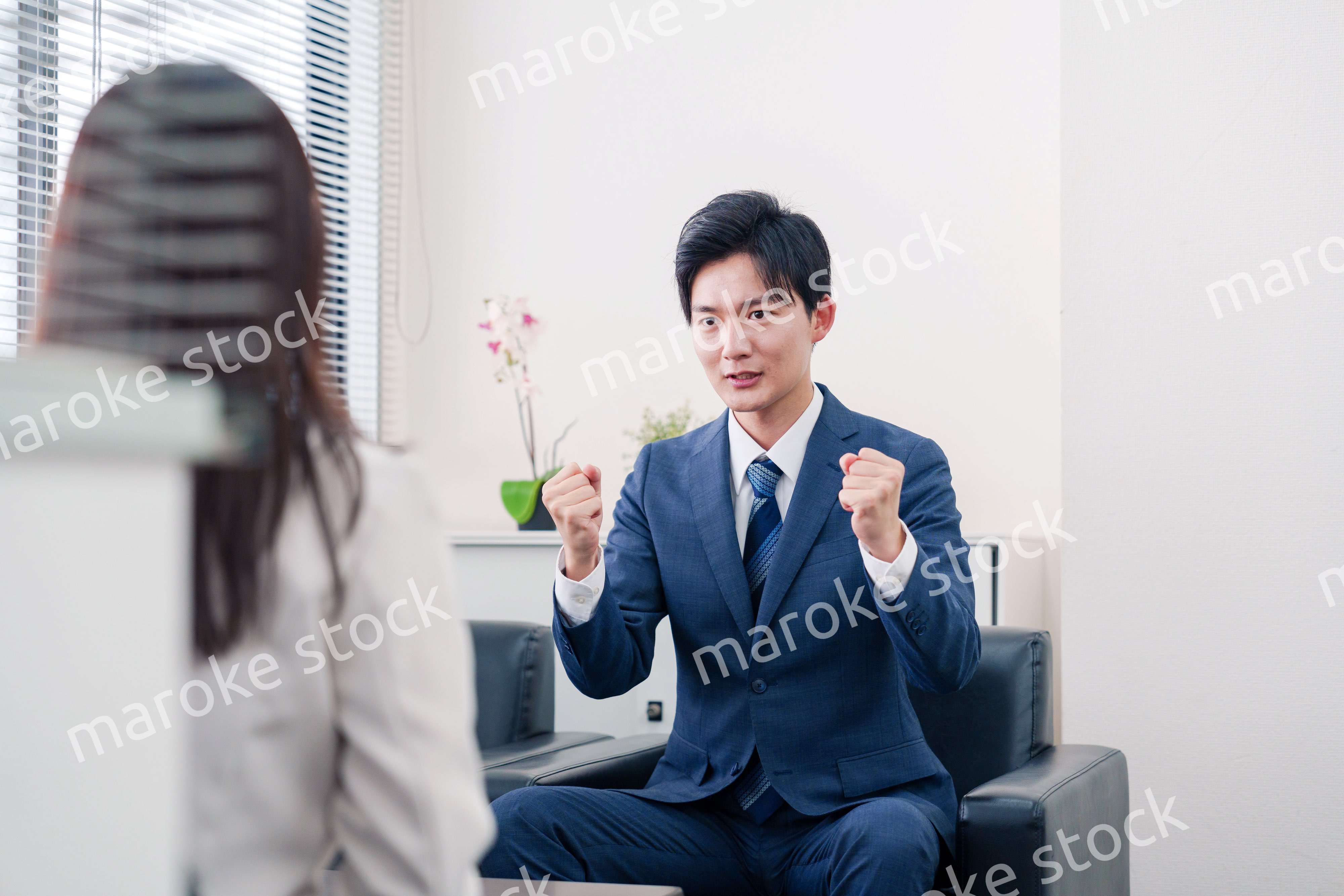 笑顔で得意先と商談をする営業マン