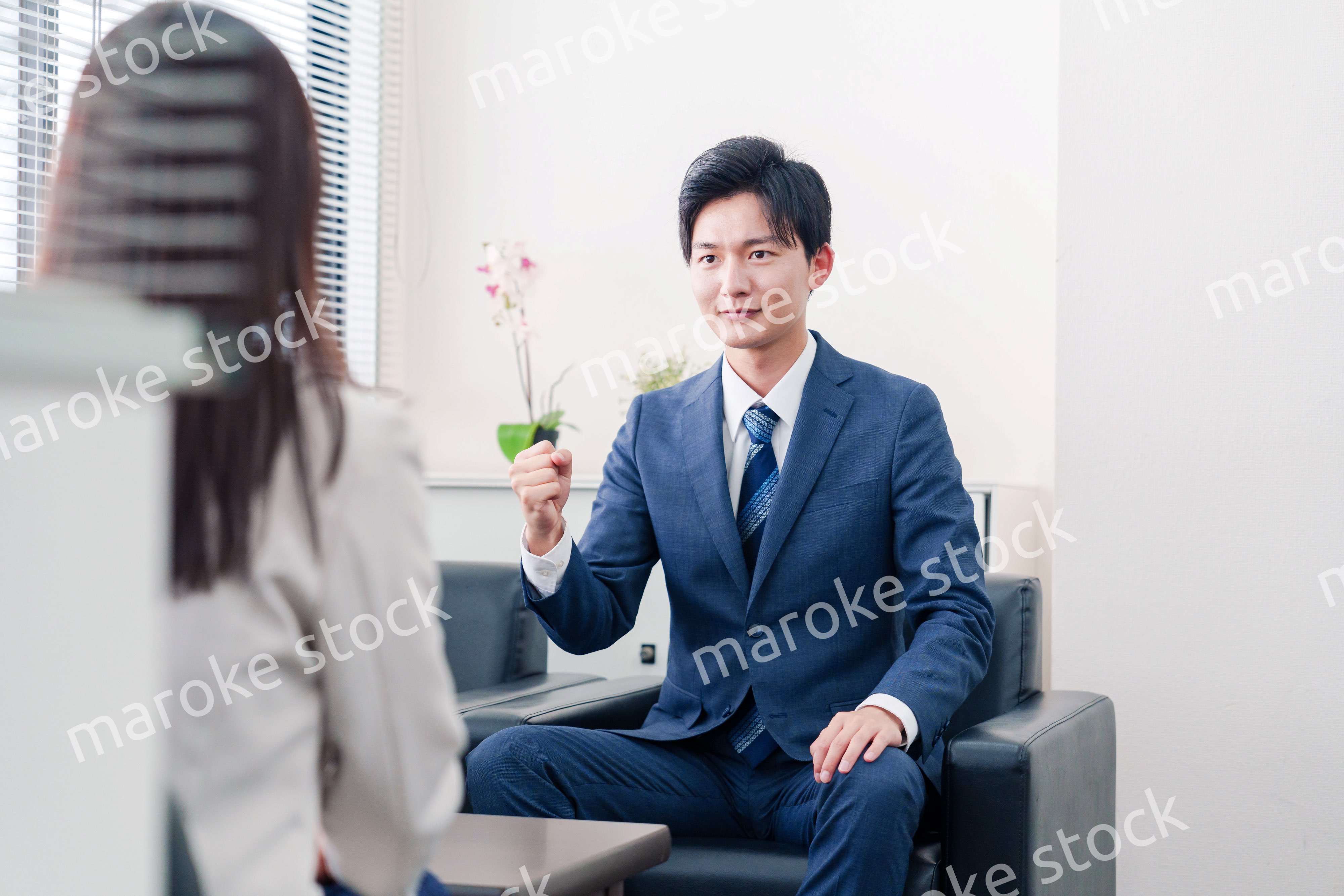 笑顔で得意先と商談をする営業マン