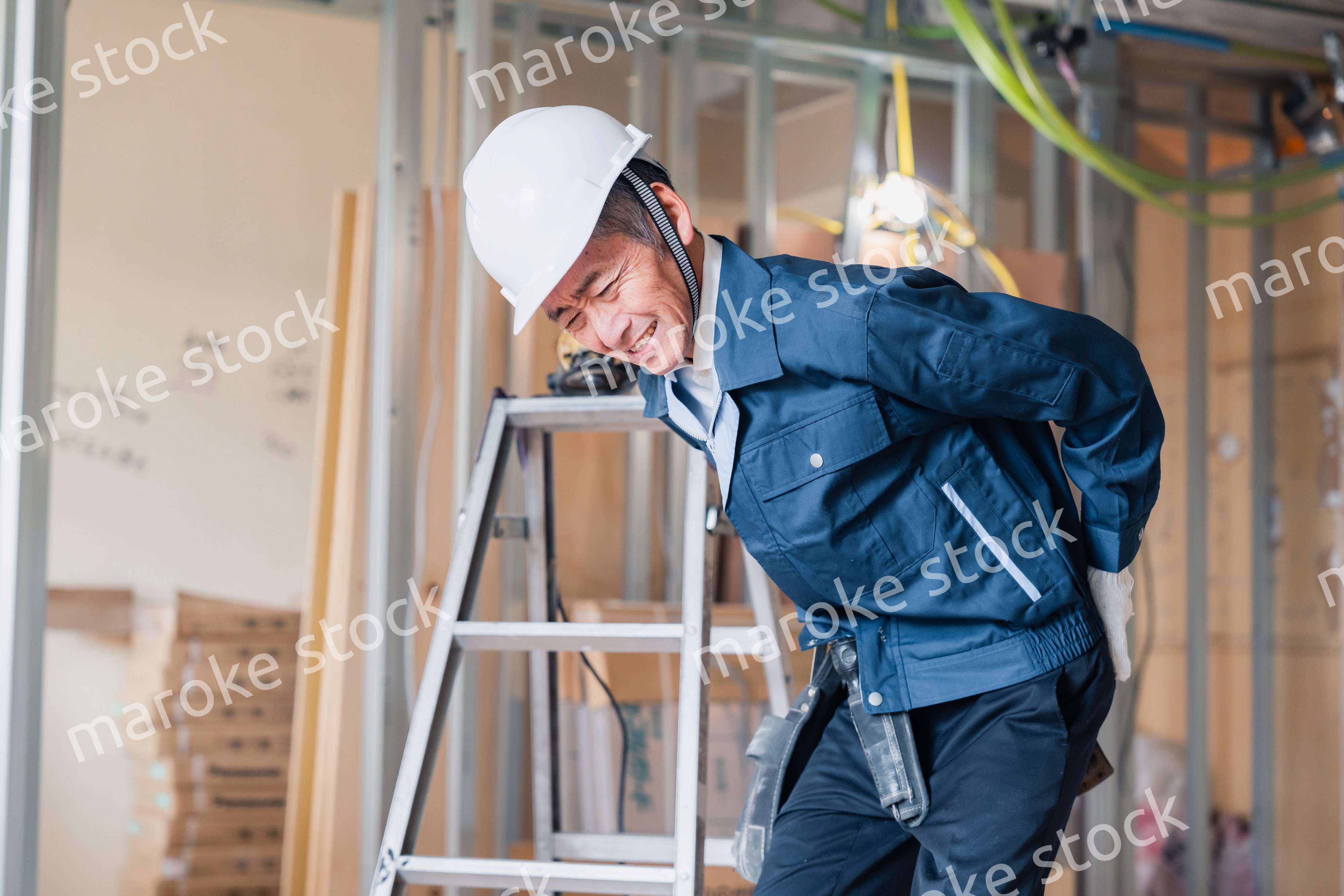 現場で腰を痛める大工