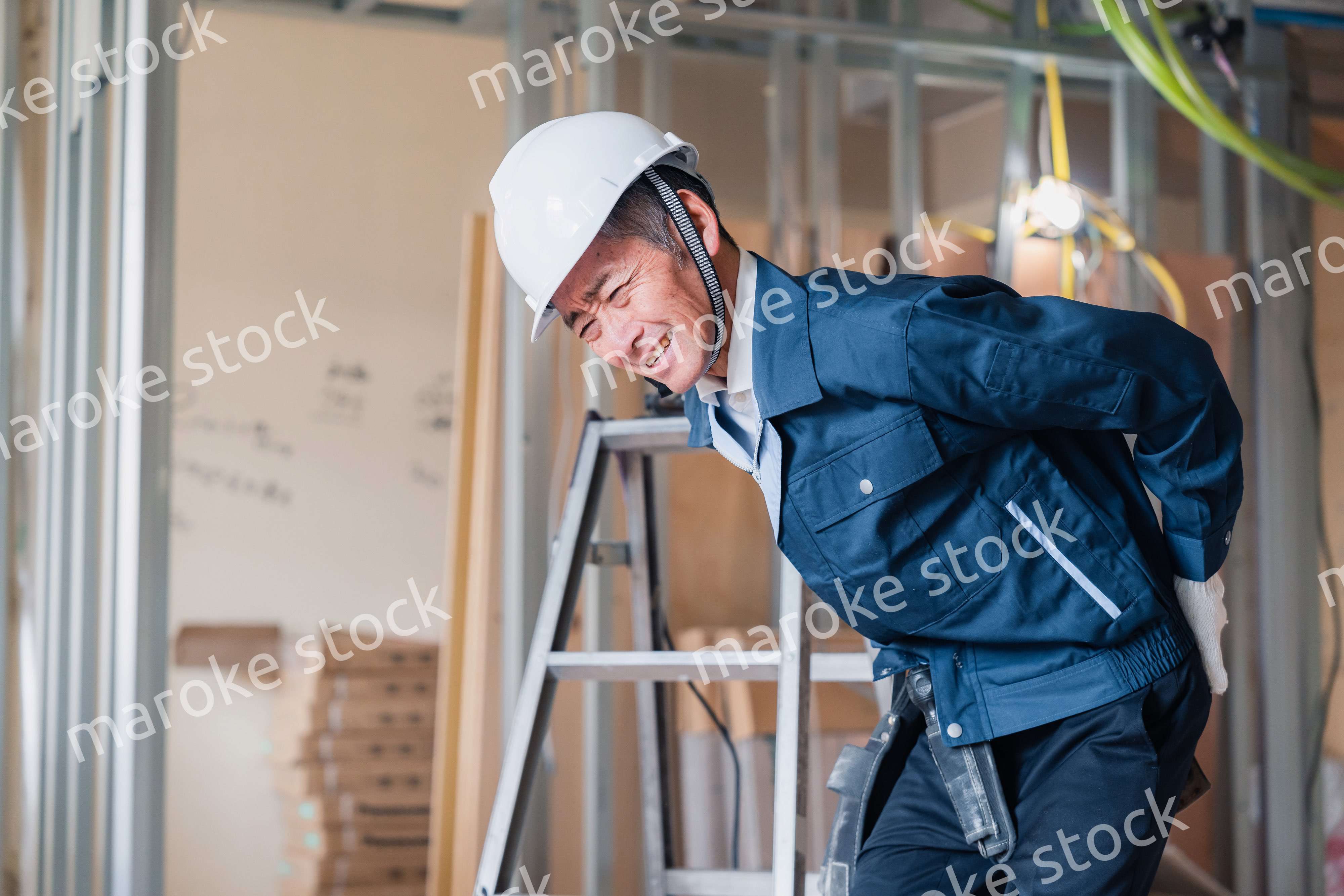 現場で腰を痛める大工