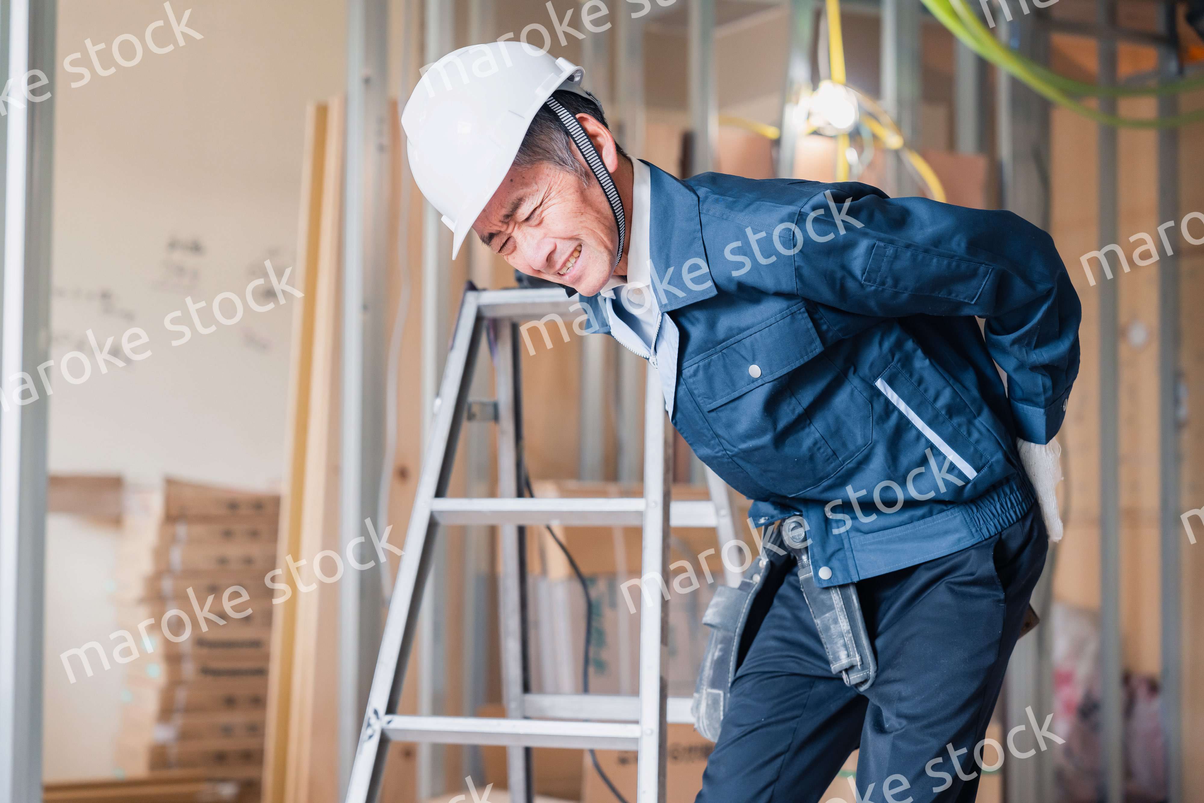 現場で腰を痛める大工