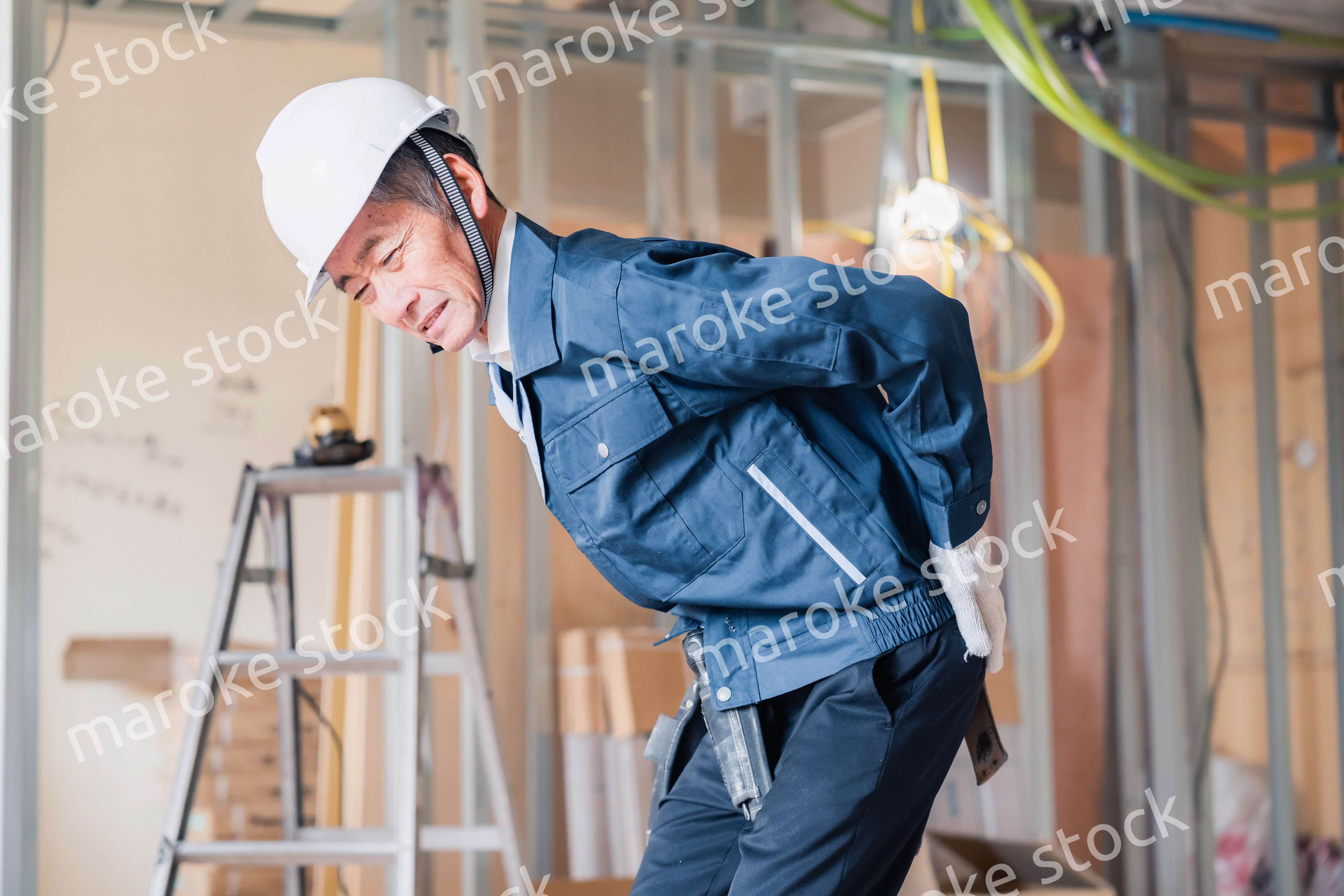 現場で腰を痛める大工