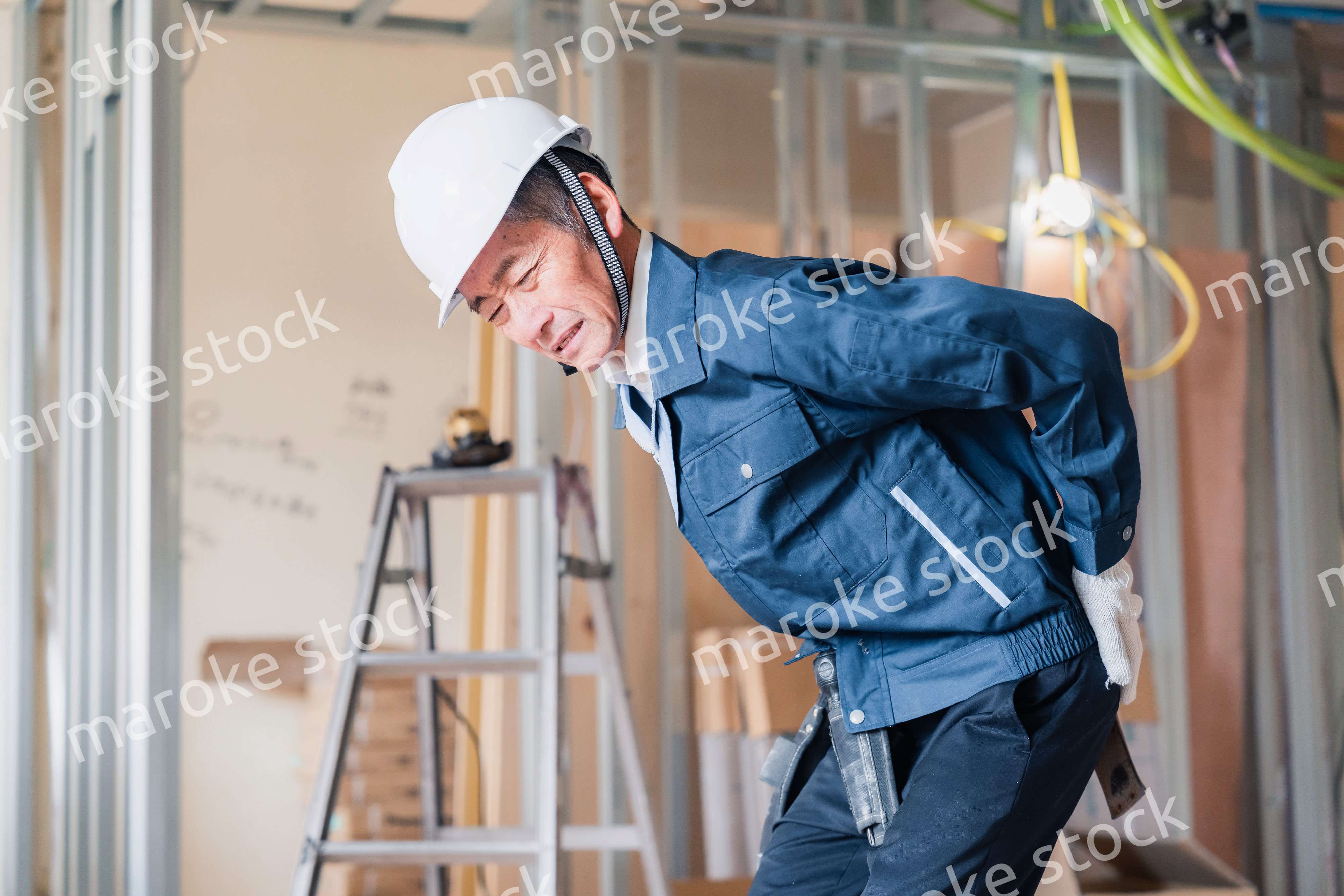 現場で腰を痛める大工