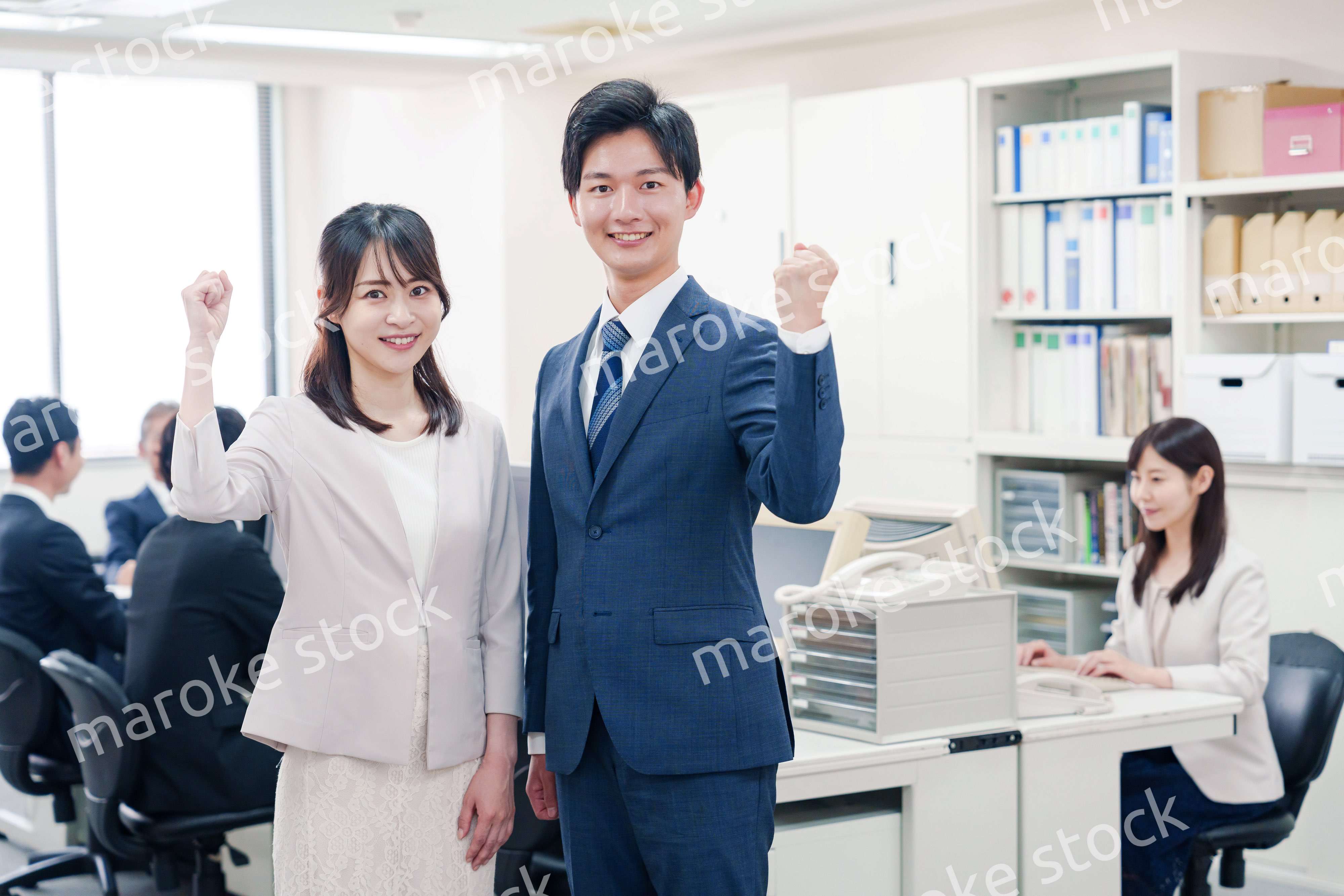 オフィスで笑顔でカメラ目線の男女のビジネスパーソン