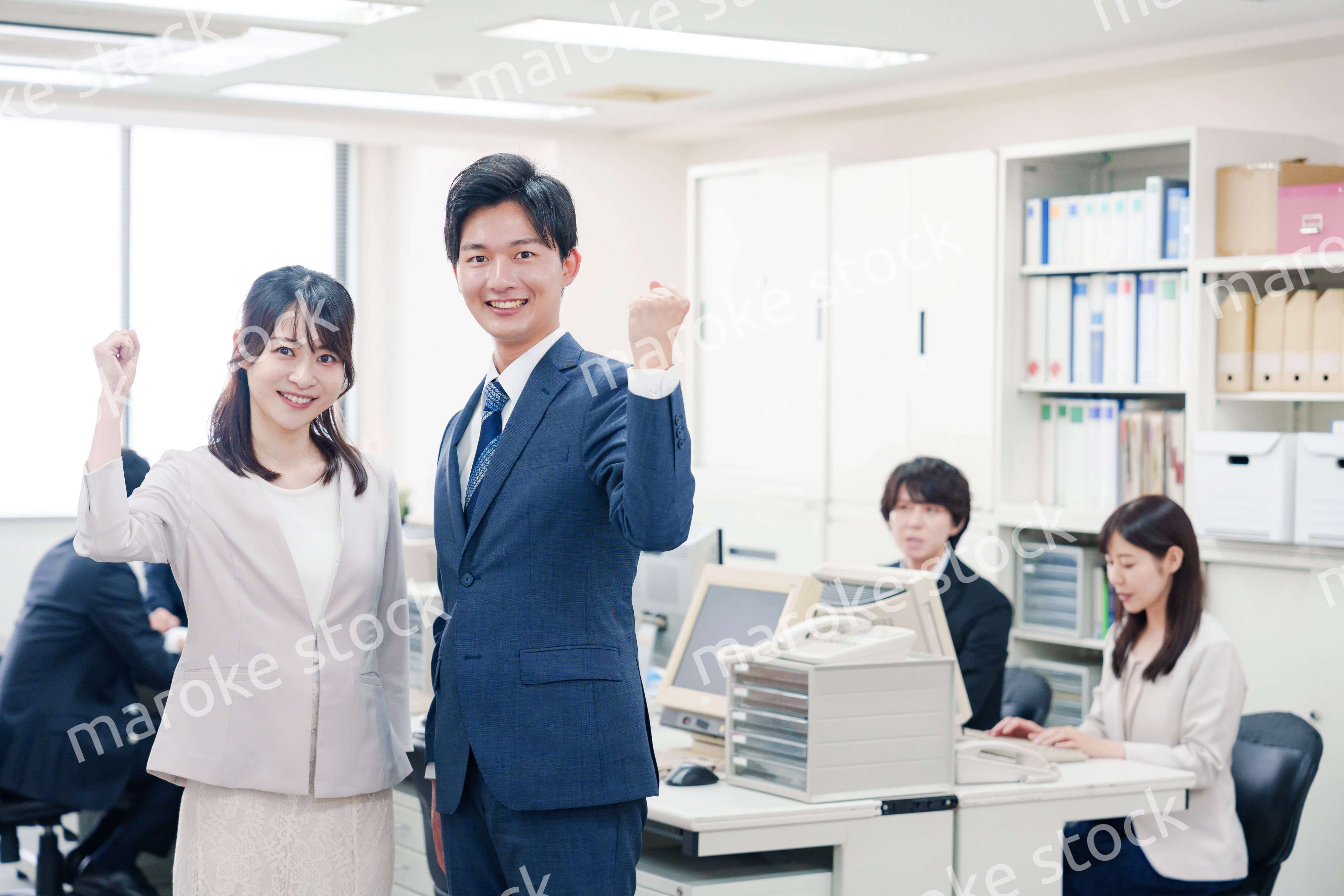 オフィスで笑顔でカメラ目線の男女のビジネスパーソン