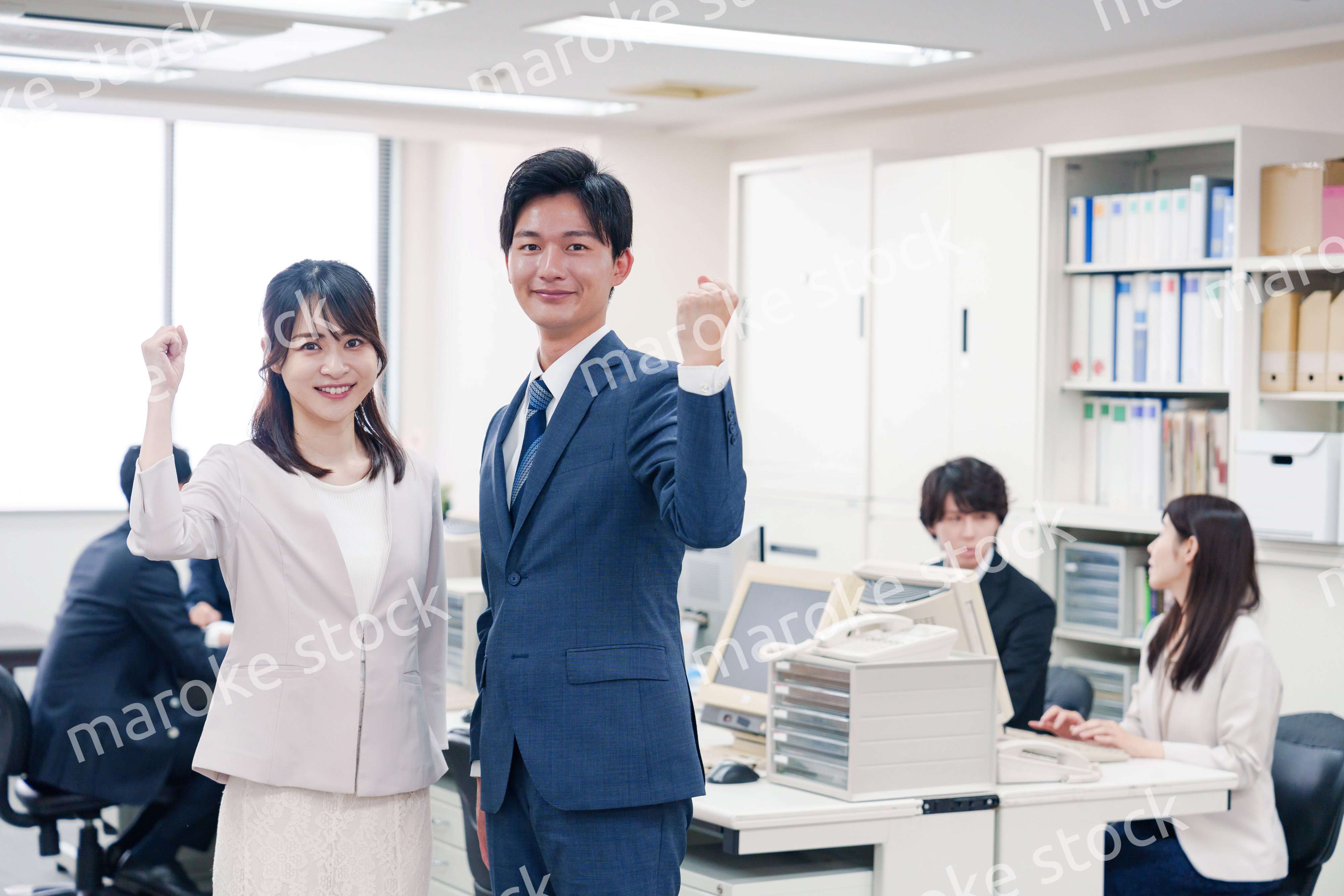 オフィスで笑顔でカメラ目線の男女のビジネスパーソン
