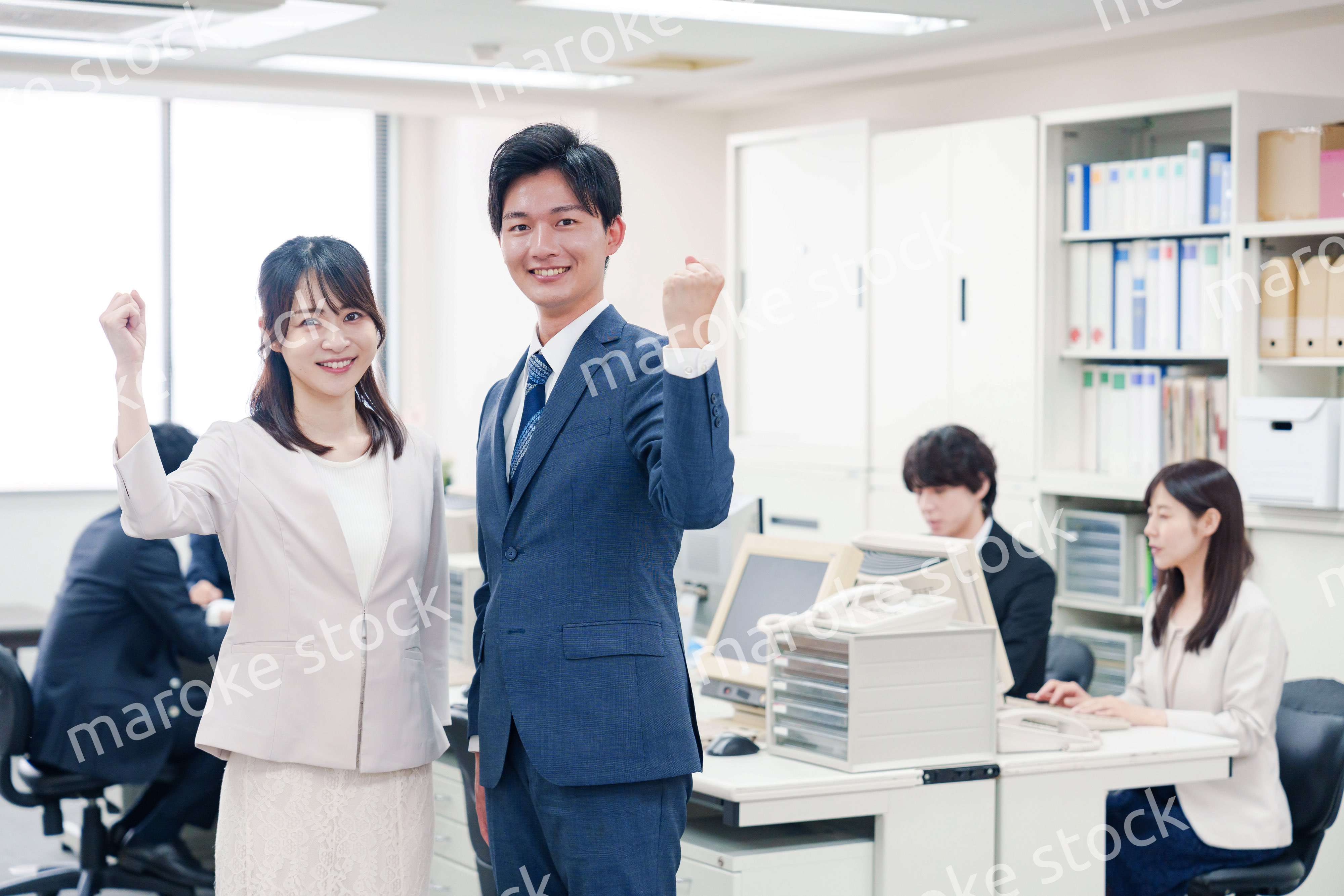 オフィスで笑顔でカメラ目線の男女のビジネスパーソン